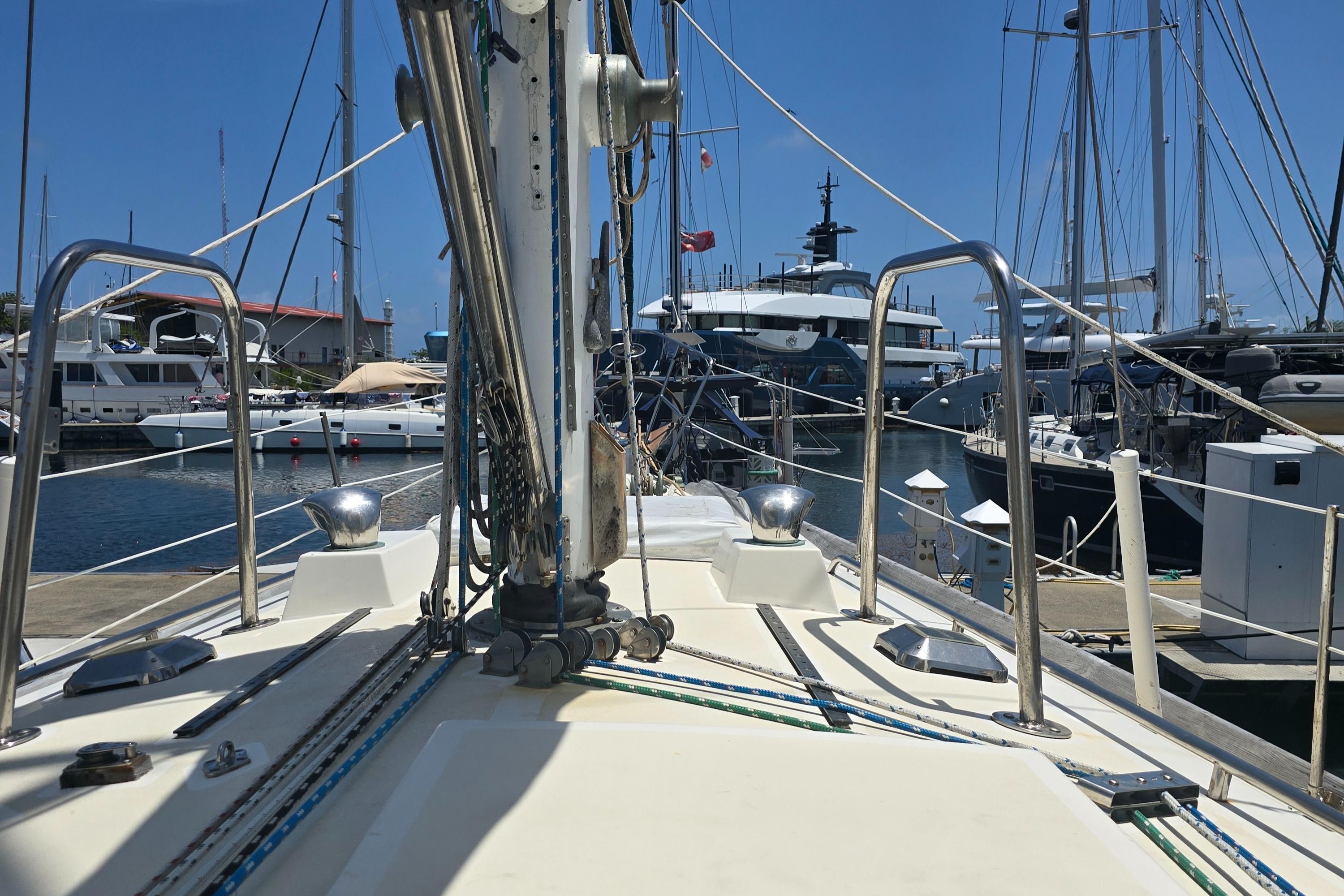 1978 Herreshoff 50 sailboat deck view in marina with other boats.