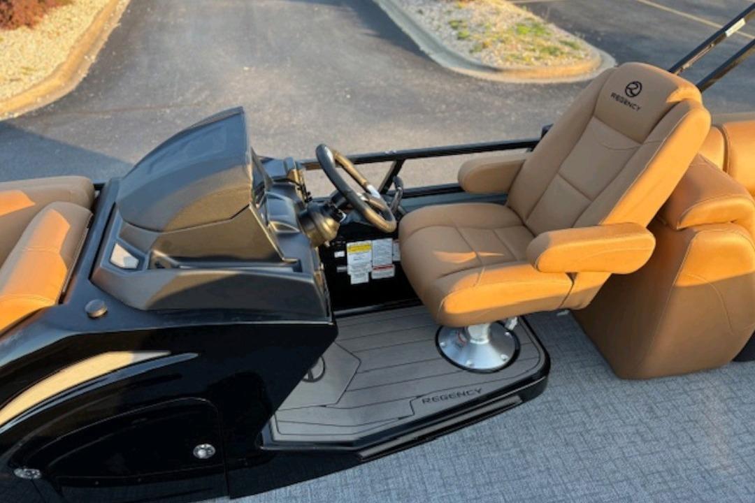 2026 Regency 230 DL boat interior with tan captain's chair and sleek black dashboard.