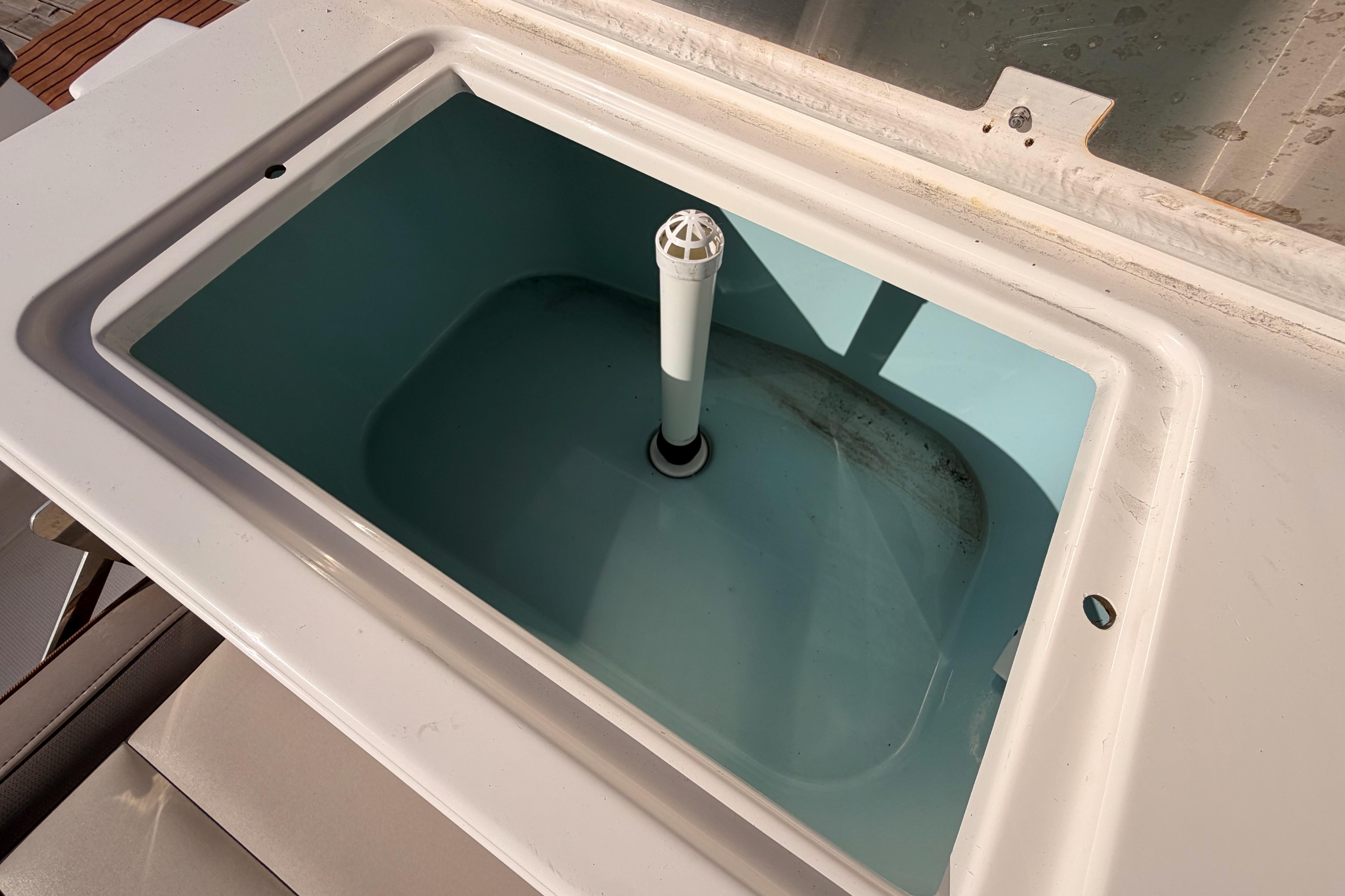 Livewell compartment on a 2021 Cutwater C-32 CB boat, featuring a central drain pipe.