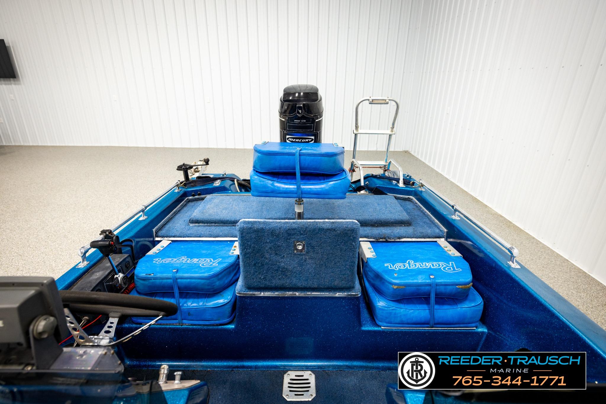 1980 Ranger 175 VS boat interior with blue seating and motor, displayed indoors.