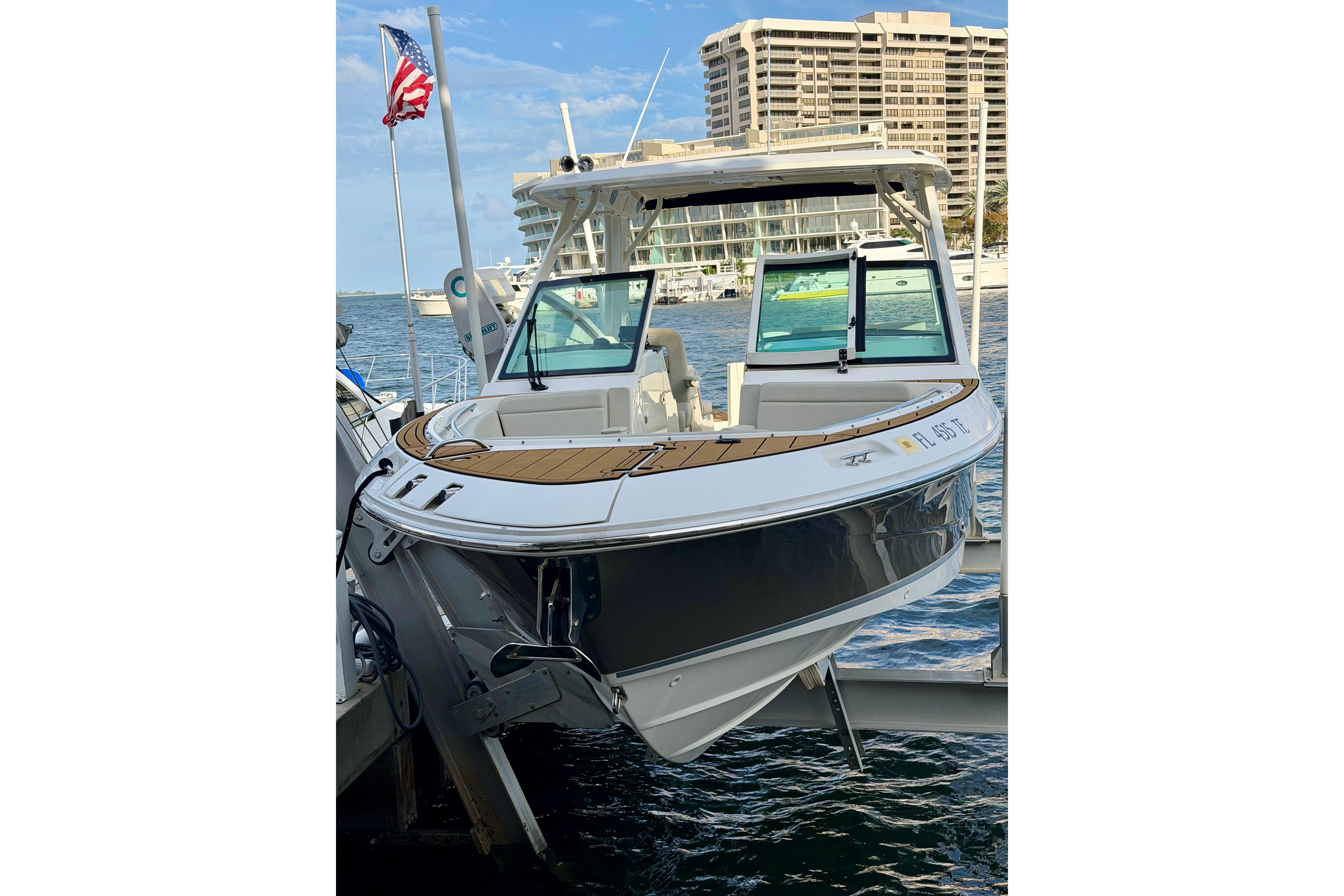 2022 Boston Whaler 280 Vantage boat docked near waterfront buildings.