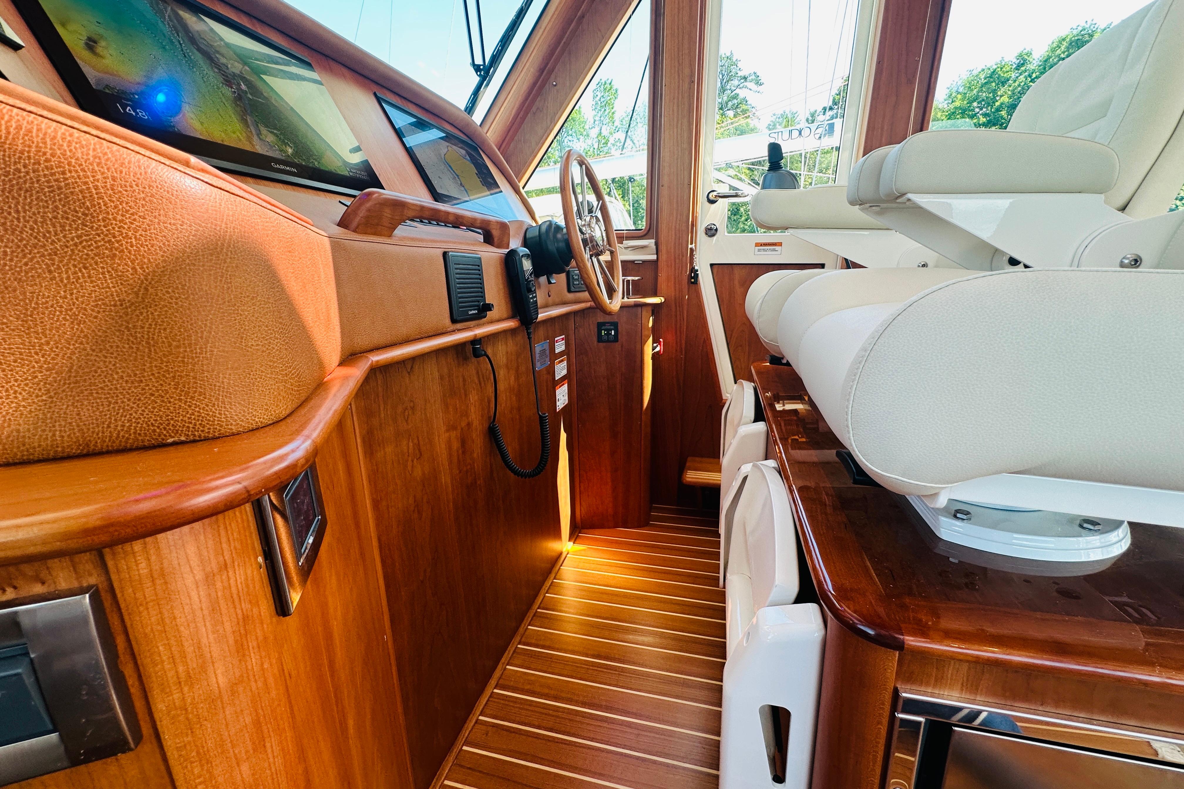 Interior of 2025 Sabre 48 Salon Express yacht with luxurious wood finish and modern controls.