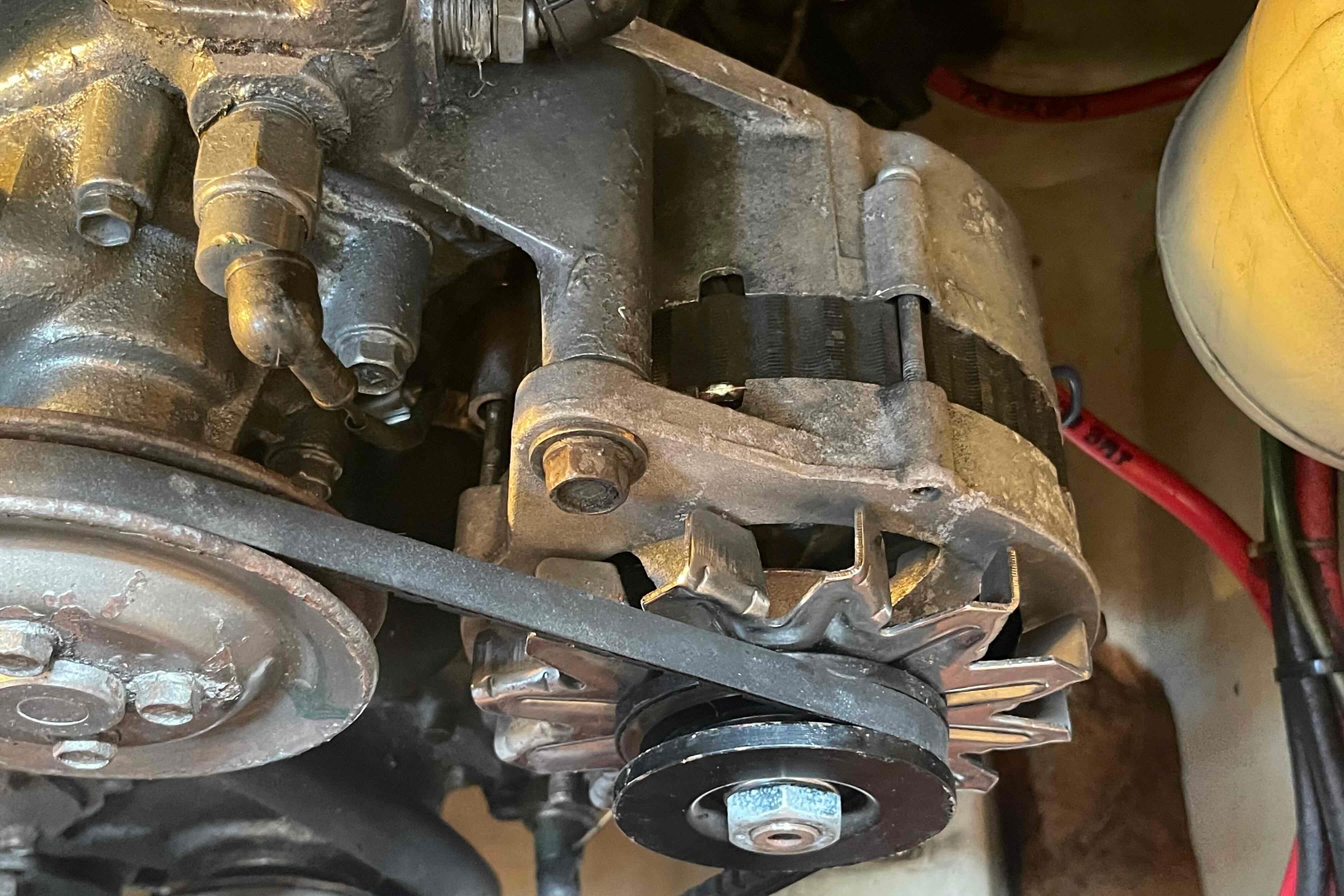 Close-up of a 1987 Pacific Seacraft 34 engine component with visible belts and pulleys.