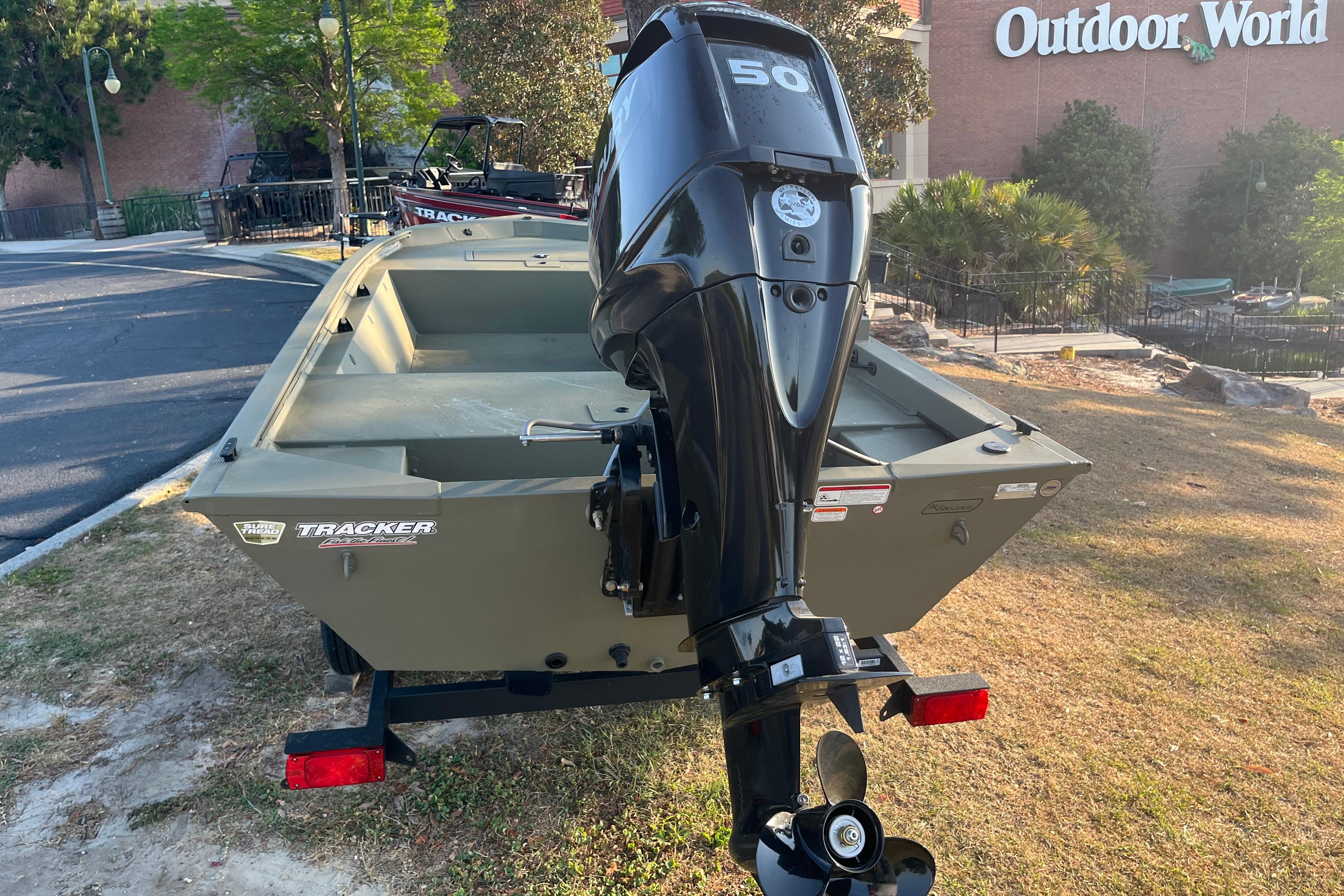 2026 Tracker Grizzly 1648 SC boat with motor, displayed outdoors near Outdoor World.