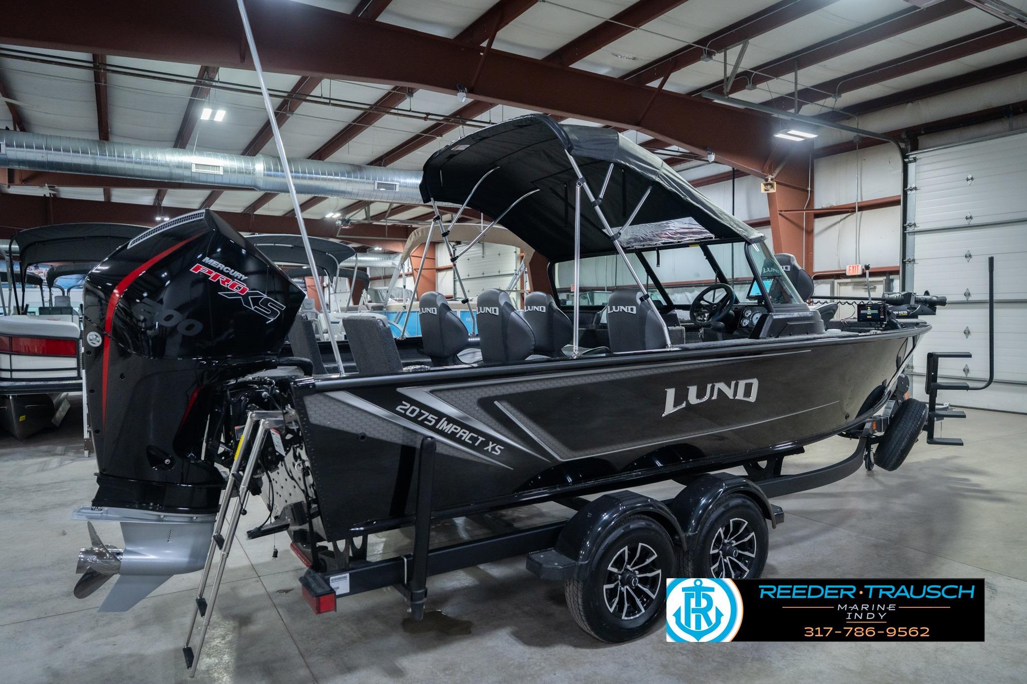 2026 Lund 2075 Impact XS boat in showroom, featuring sleek design and powerful engine.
