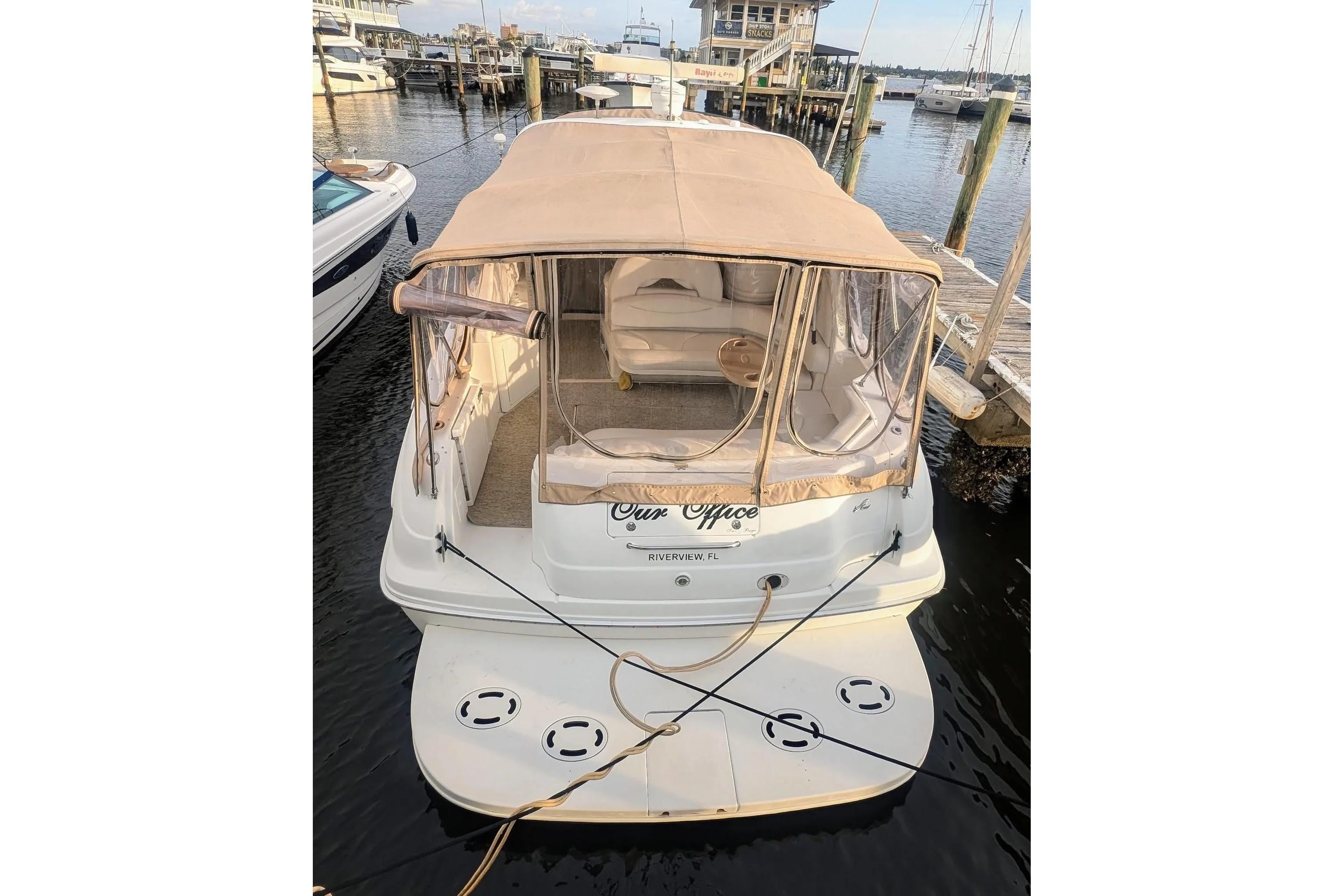 2000 Sea Ray 380 Sundancer docked at marina with beige canopy.