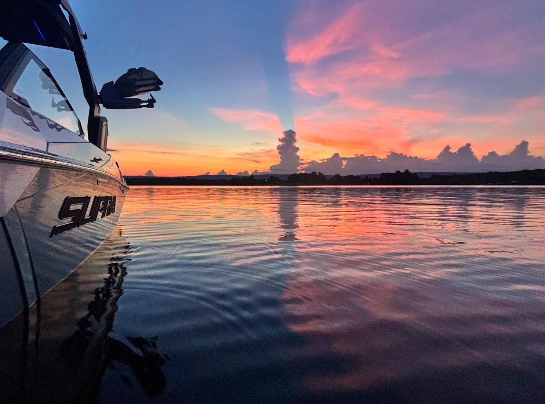 2025 Supra SA 450 boat at sunset on calm water.