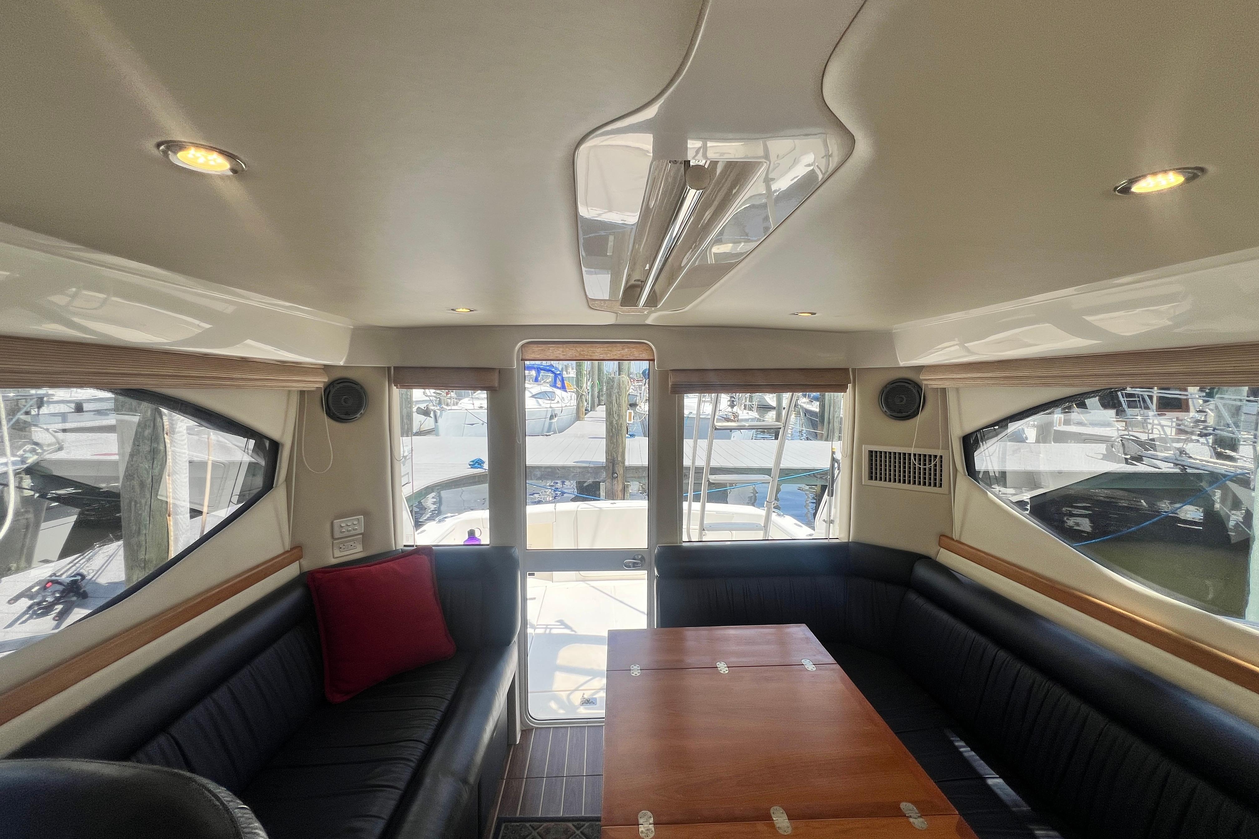 Interior of 2007 Riviera 33 Flybridge yacht with elegant seating and wooden table.
