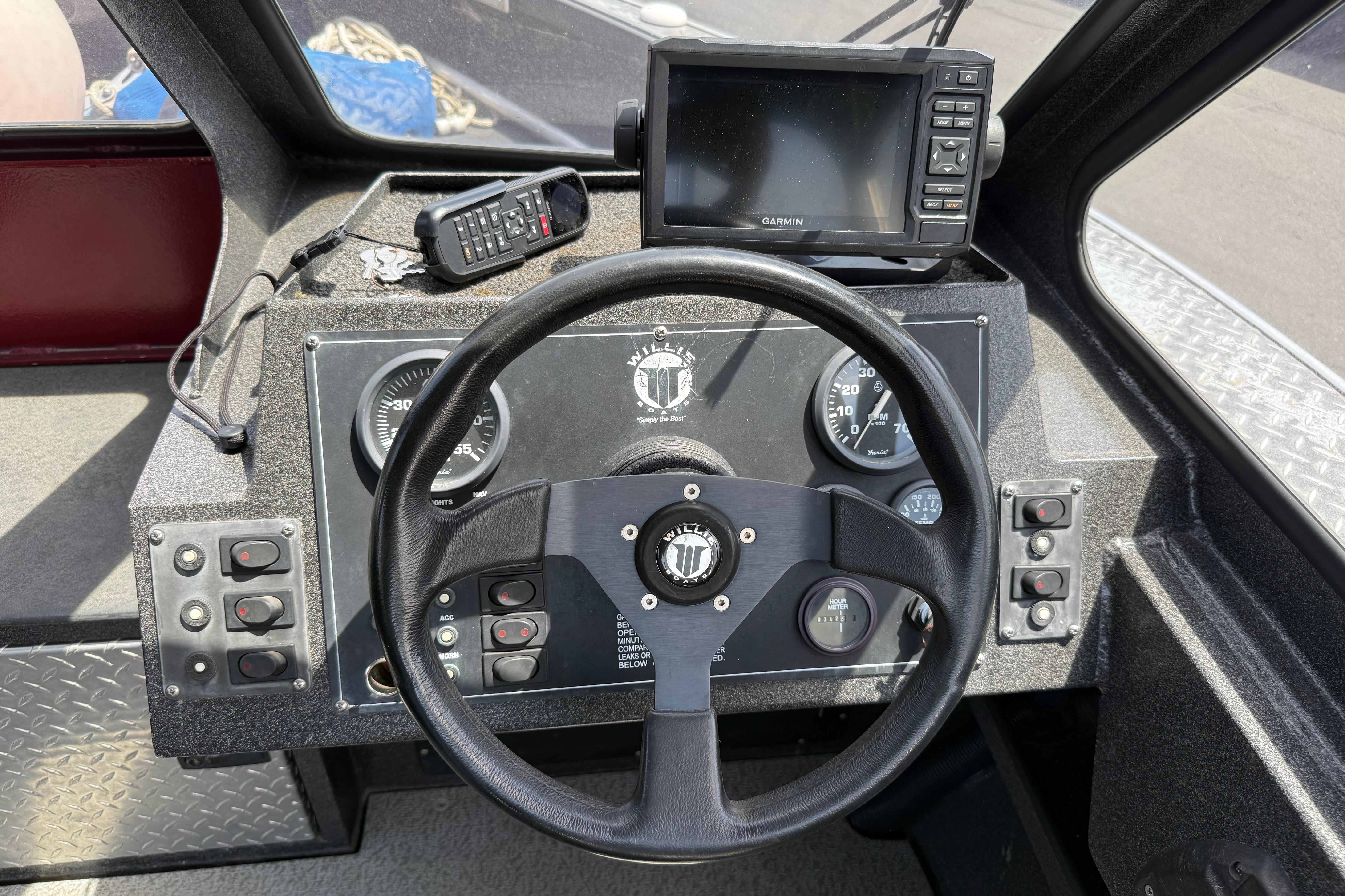 Dashboard of a 2005 Willie Raptor 21' boat with steering wheel and navigation equipment.