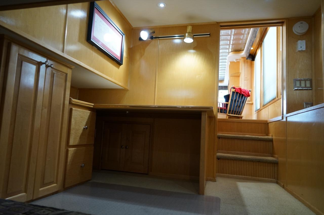 Interior of 2000 Stardust Cruisers houseboat with wooden cabinetry and carpeted stairs.