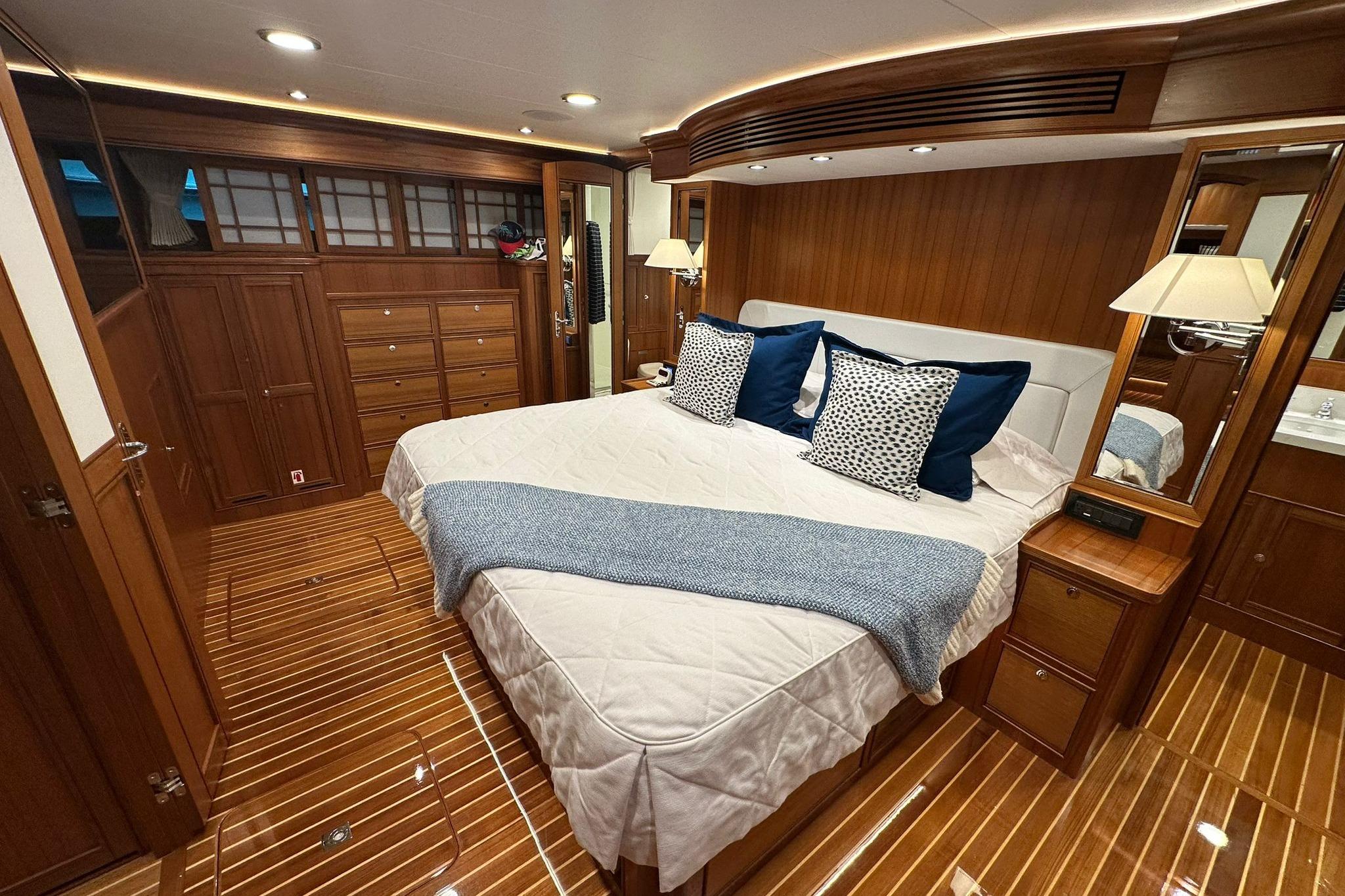 Luxurious cabin interior of 2023 Marlow Explorer 66E-CB yacht with elegant wood finish.