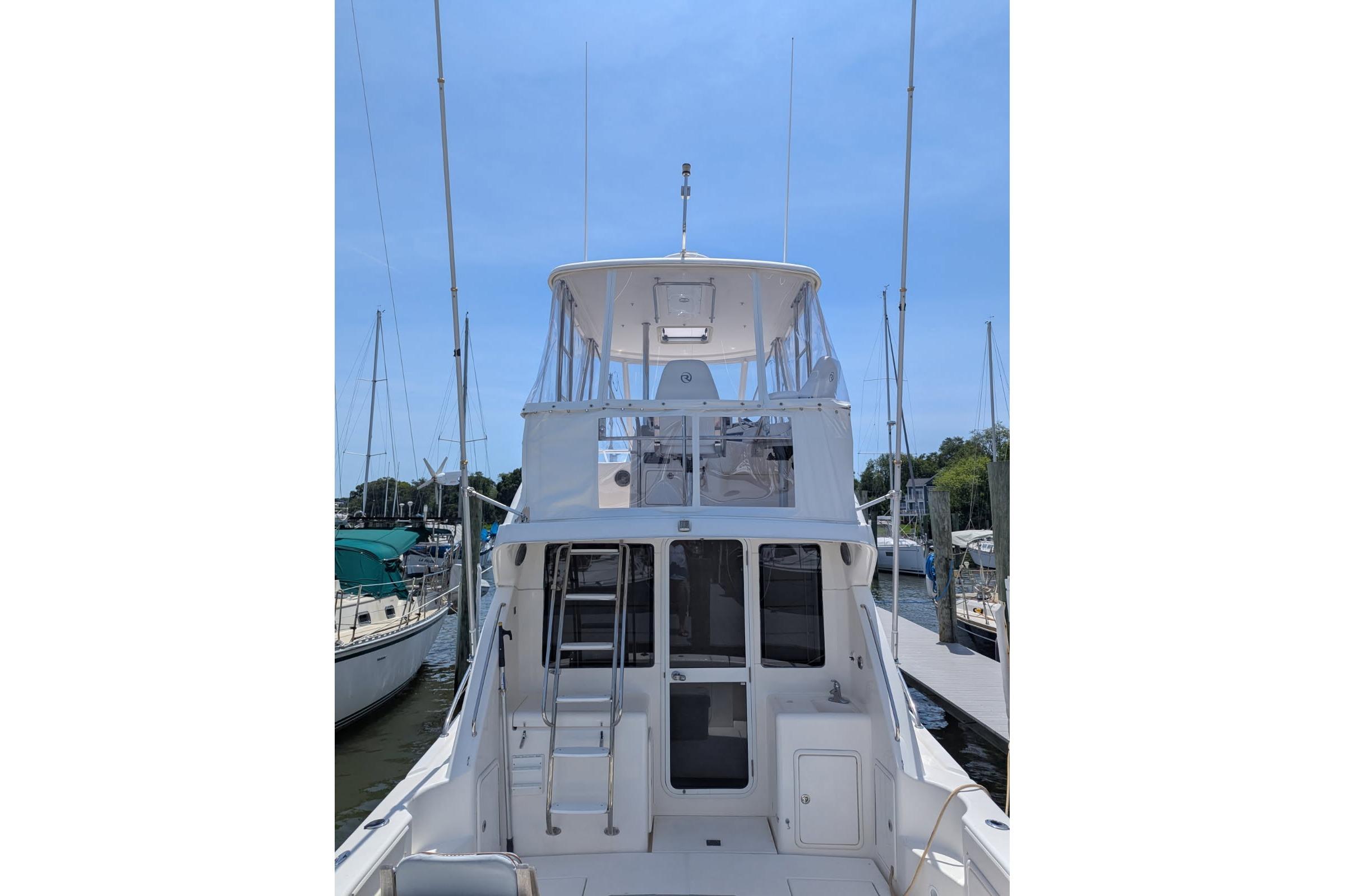 2007 Riviera 33 Flybridge yacht docked at marina, showcasing rear view and flybridge.