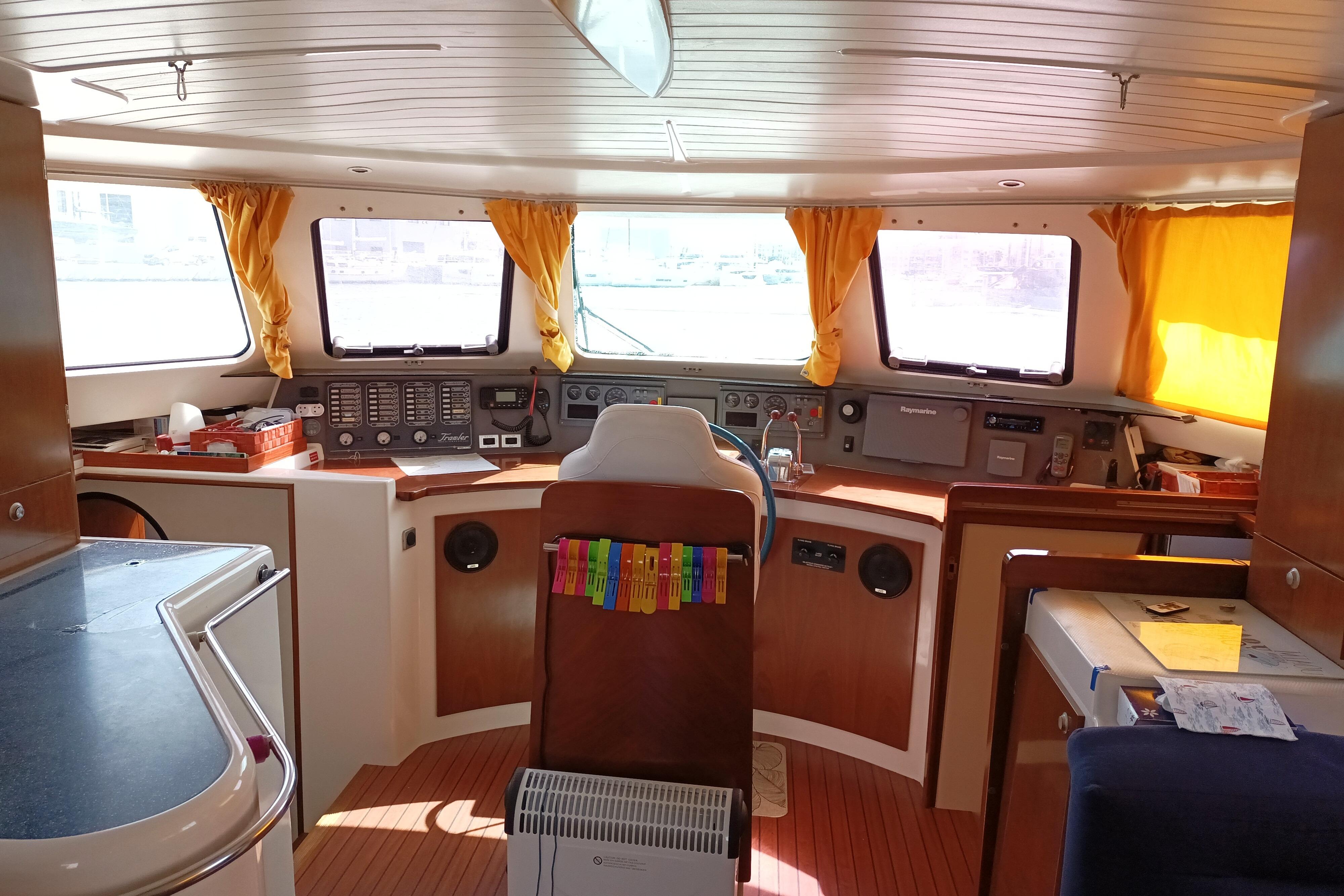 Interior of 2004 Fountaine Pajot Maryland 37 yacht with helm and yellow curtains.