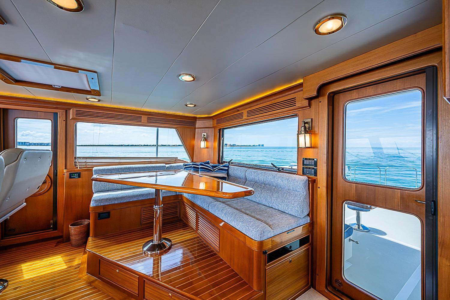 Luxurious interior of 2014 Marlow 80 Explorer yacht with ocean view and elegant wood finish.