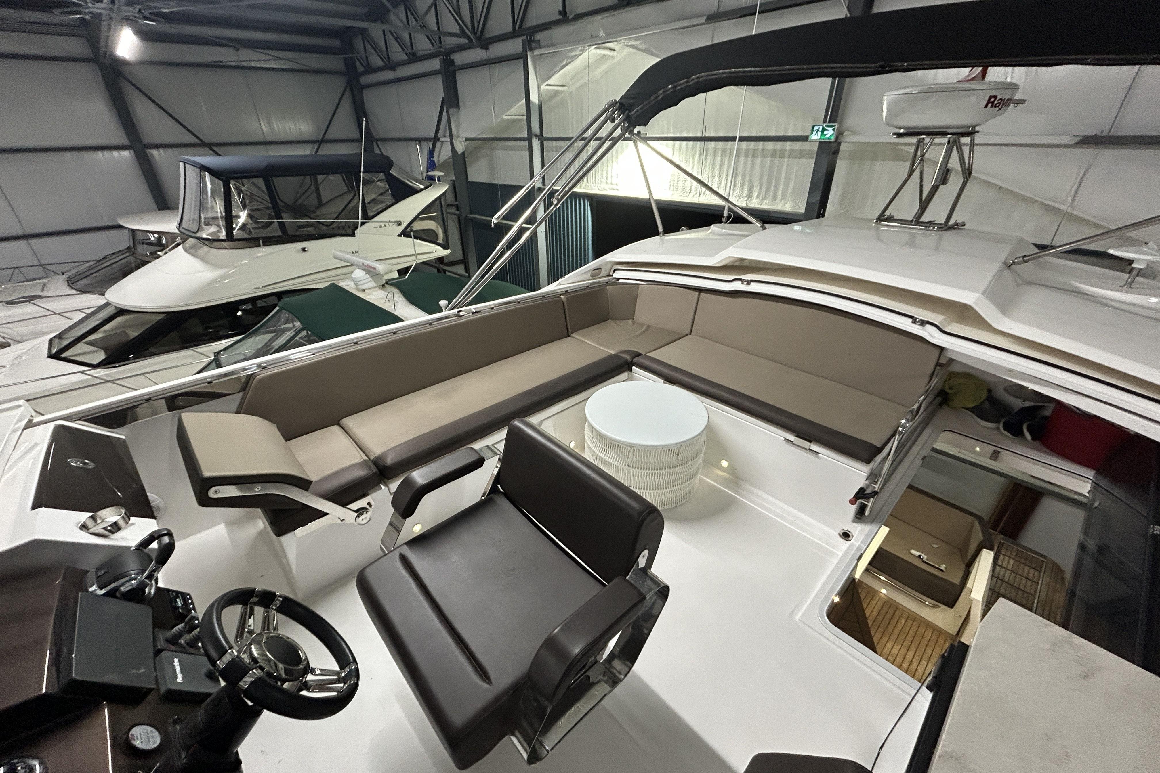 2018 Galeon 560 Sky yacht interior with seating and helm in a storage facility.