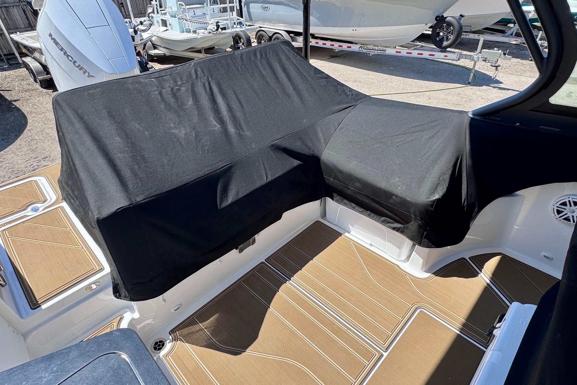 2026 Monterey Elite 27 OB boat interior with covered seating and teak-style flooring.