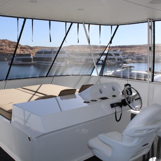 Helm of 2016 Adonia Atlantis Trip 8 houseboat with marina view.