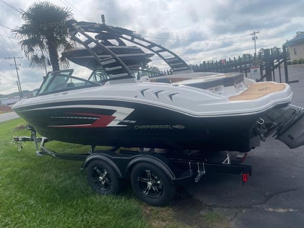 2025 Chaparral 21 SSi boat on trailer, parked outdoors, with overcast sky.