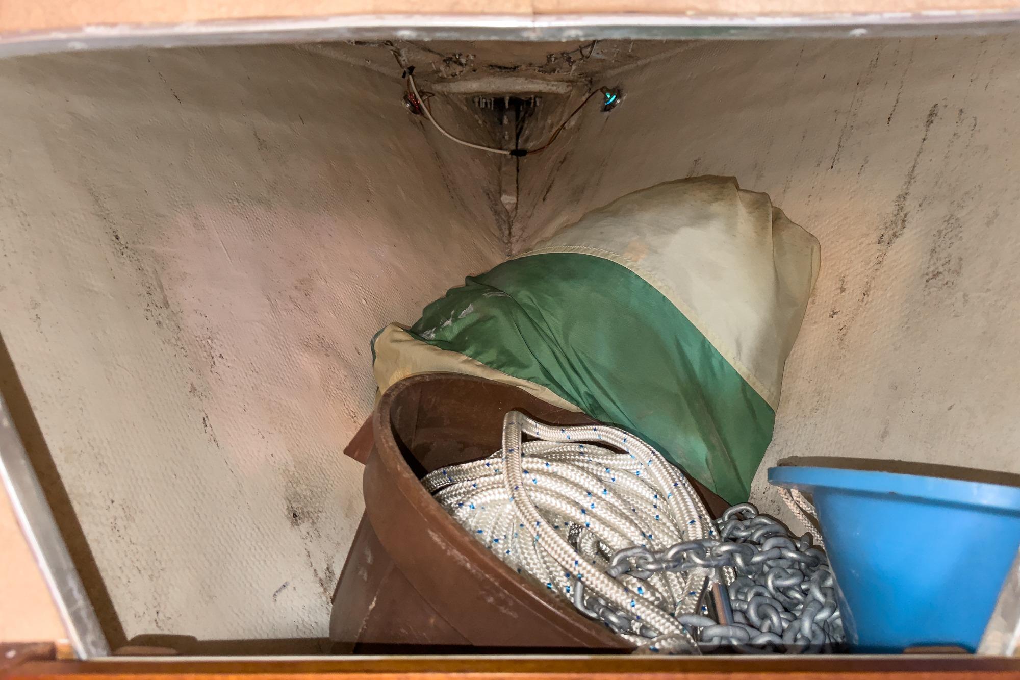Storage area in a 1970 Morgan 42 MKI sailboat with ropes, chains, and a tarp.