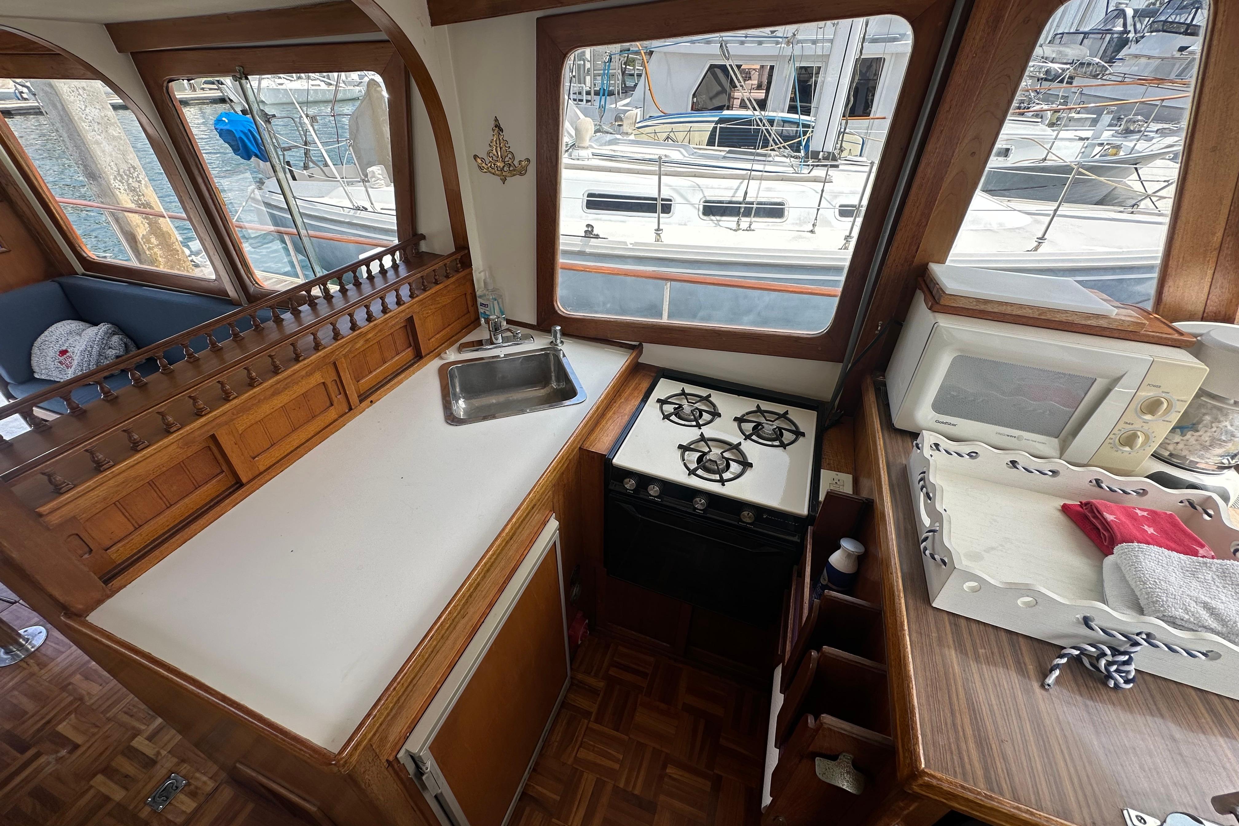 1973 CHB 33 boat interior with kitchen, stove, sink, and microwave, docked at marina.