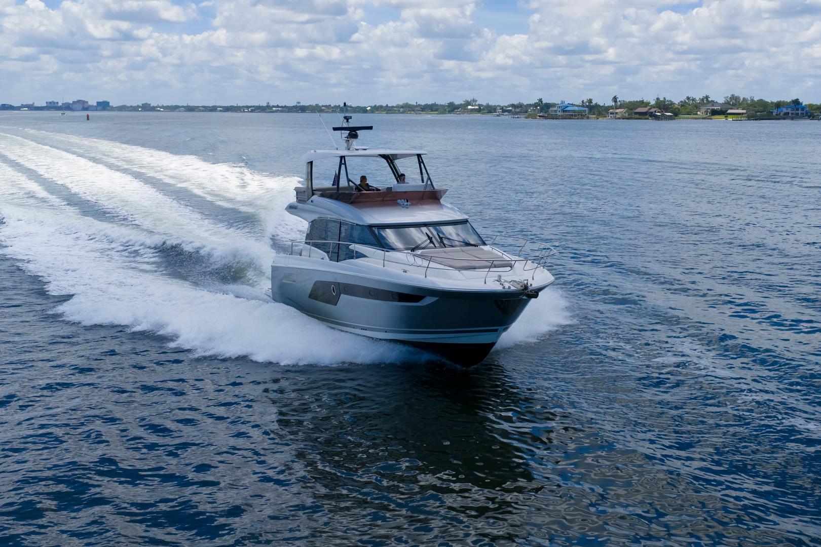 Luxury 2022 Prestige 520 yacht cruising on open water under a cloudy sky.