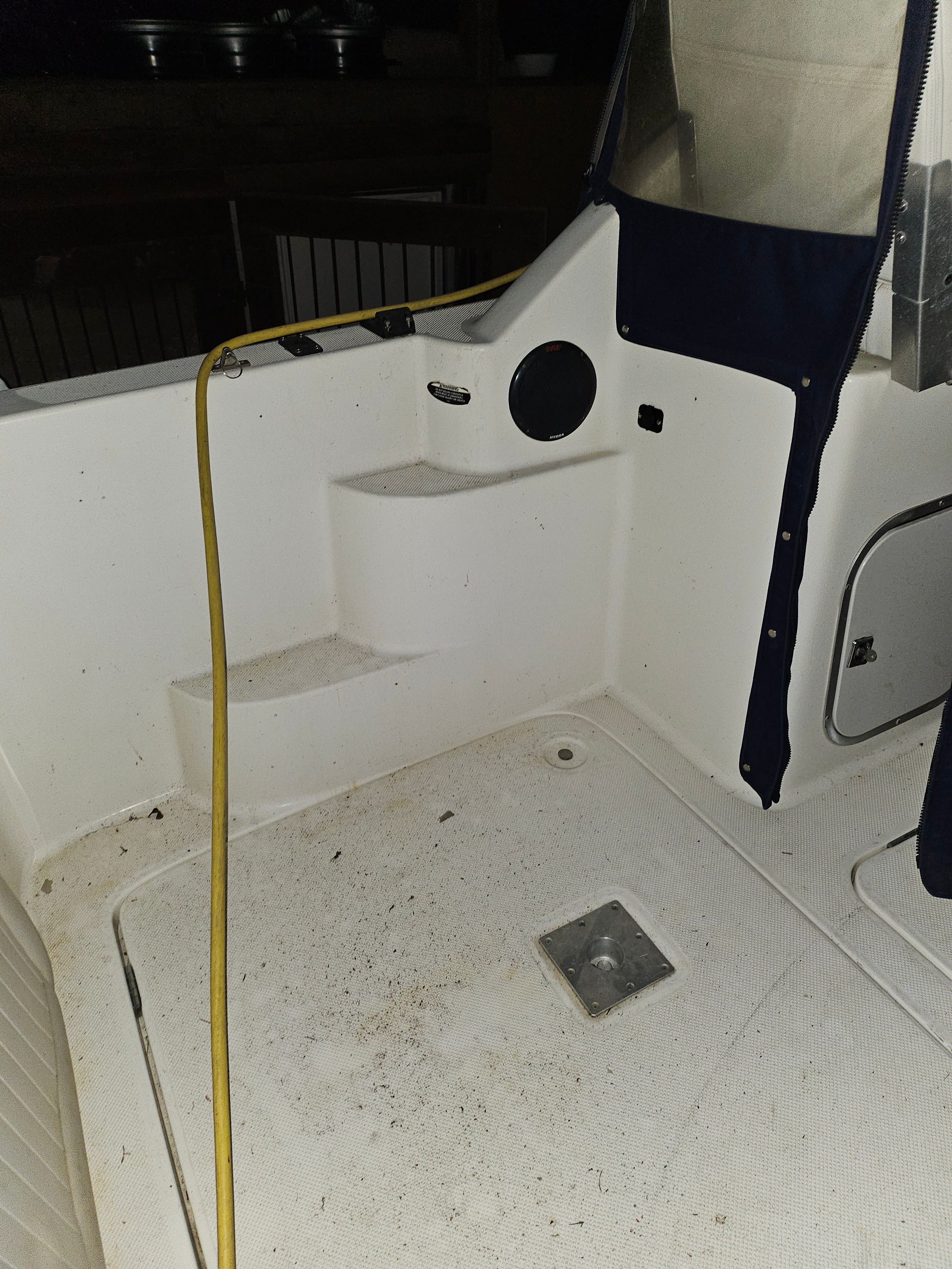 The image shows the cockpit of a 2005 Bayliner 242 Ceara with white steps and a yellow cable.