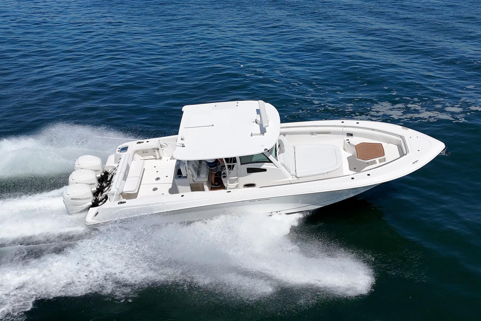 2015 Boston Whaler 370 Outrage speeding on open water, showcasing powerful engines and sleek design.