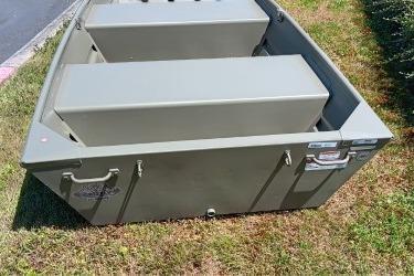 2026 Tracker Grizzly 10 Jon boat on grass, showcasing sturdy design and storage compartments.