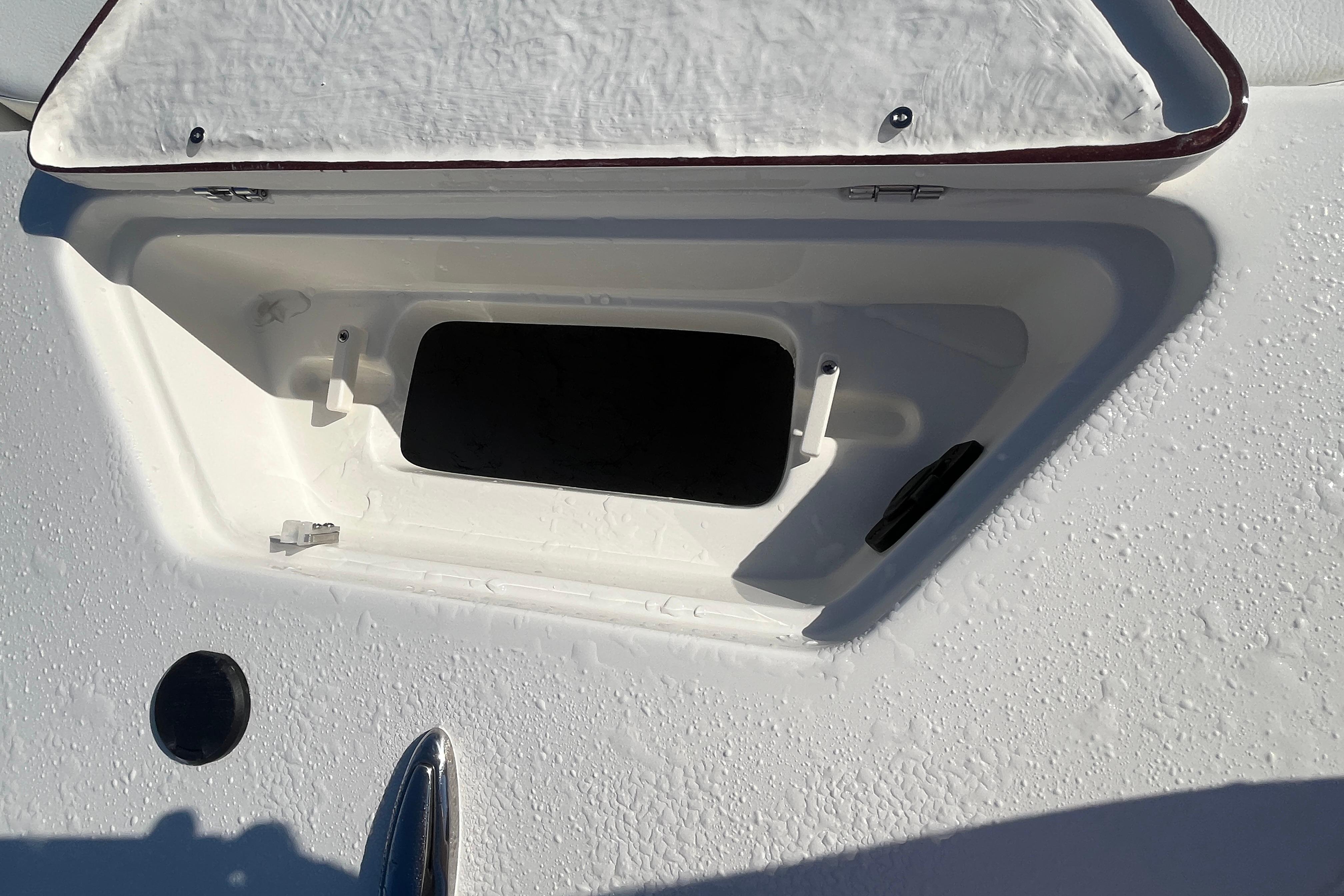 Open storage compartment on a 2026 Bulls Bay 2200 boat, with water droplets visible.