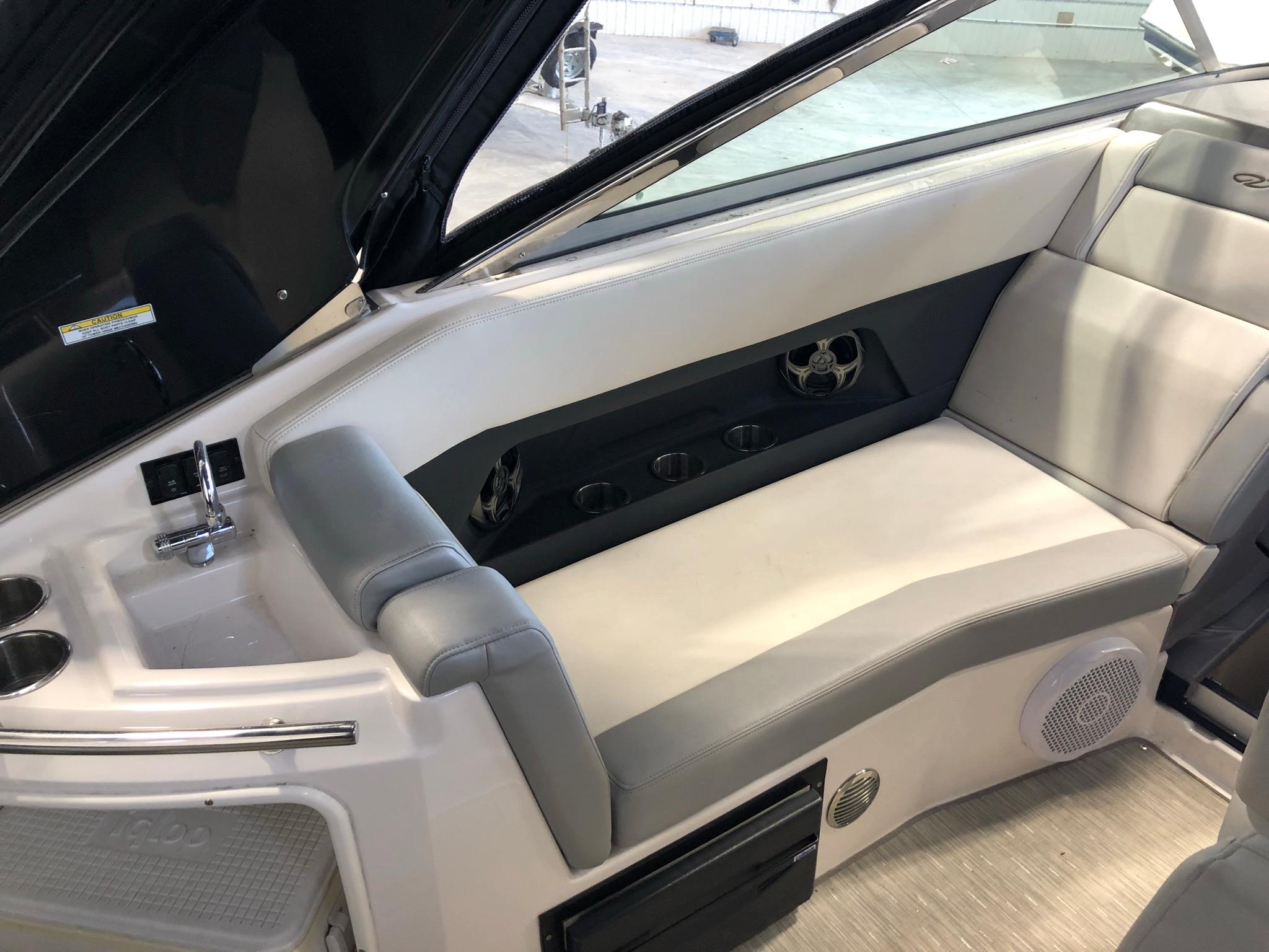 2015 Regal 28 Express boat interior seating area with cup holders and speaker.