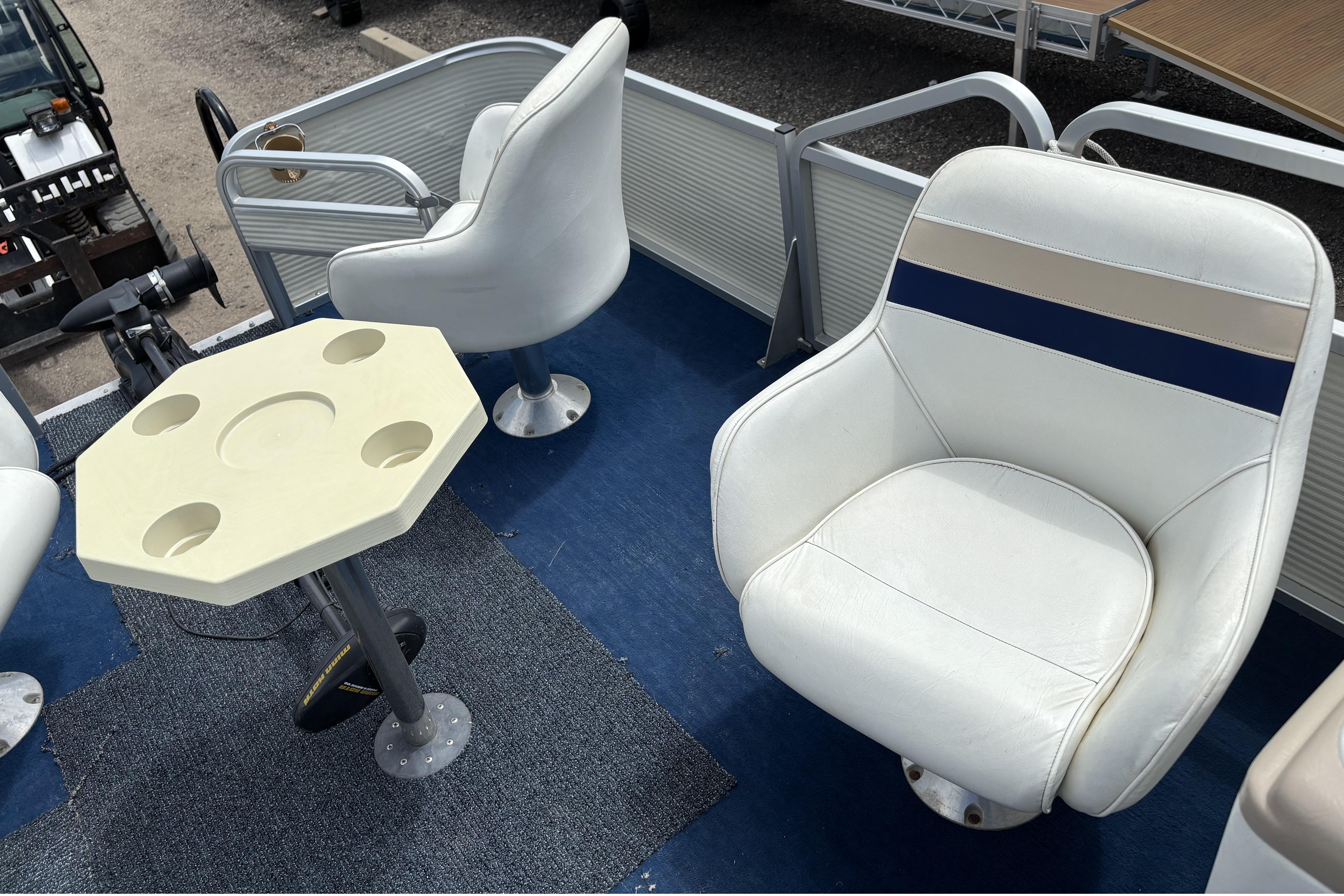 1997 Northwood 24' Pontoon interior with white seating and a beige table.