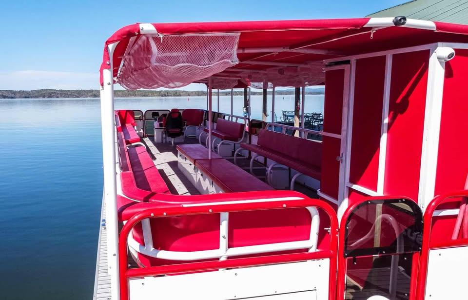 2024 Aloha Pontoon 50' Water Taxi with red seating on a calm lake.