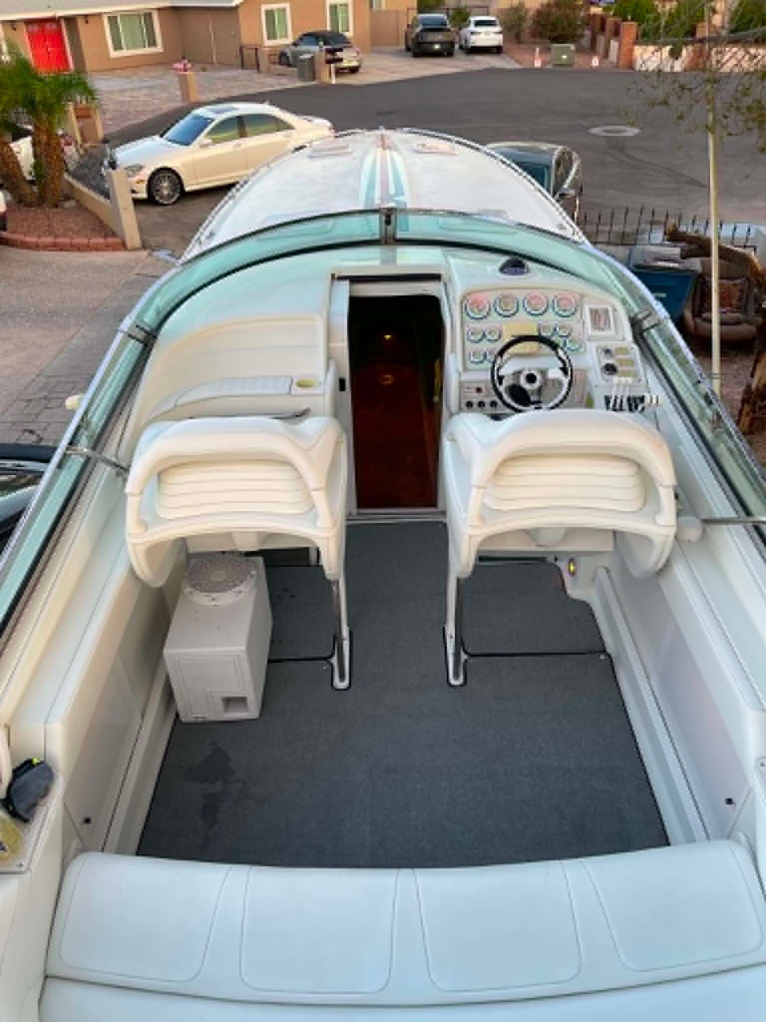 The image shows a boat cockpit with two white seats and a steering console.