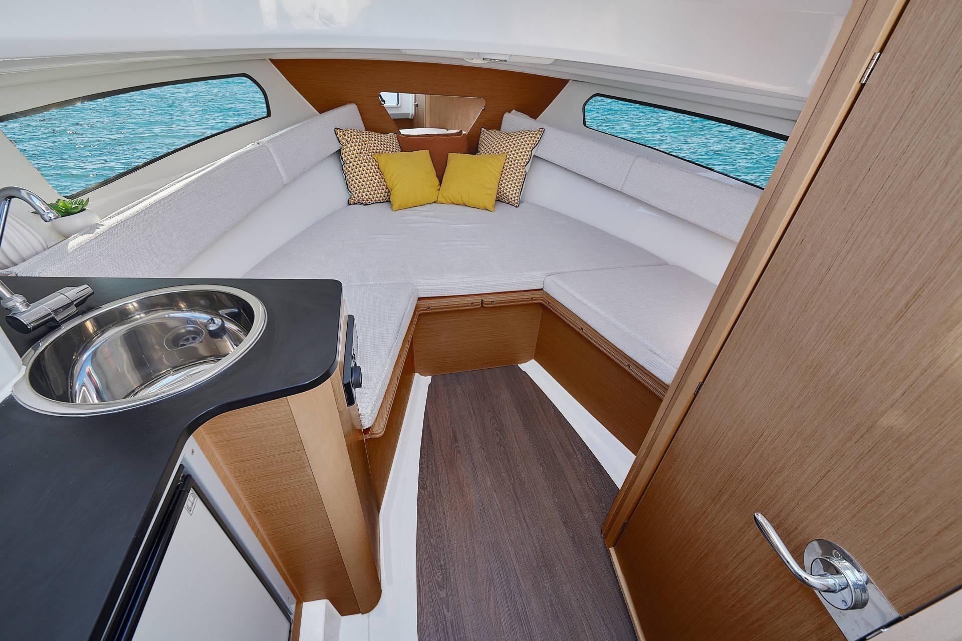 Interior of 2026 Jeanneau Cap Camarat 7.5 WA Serie 3, featuring cozy seating and kitchenette.