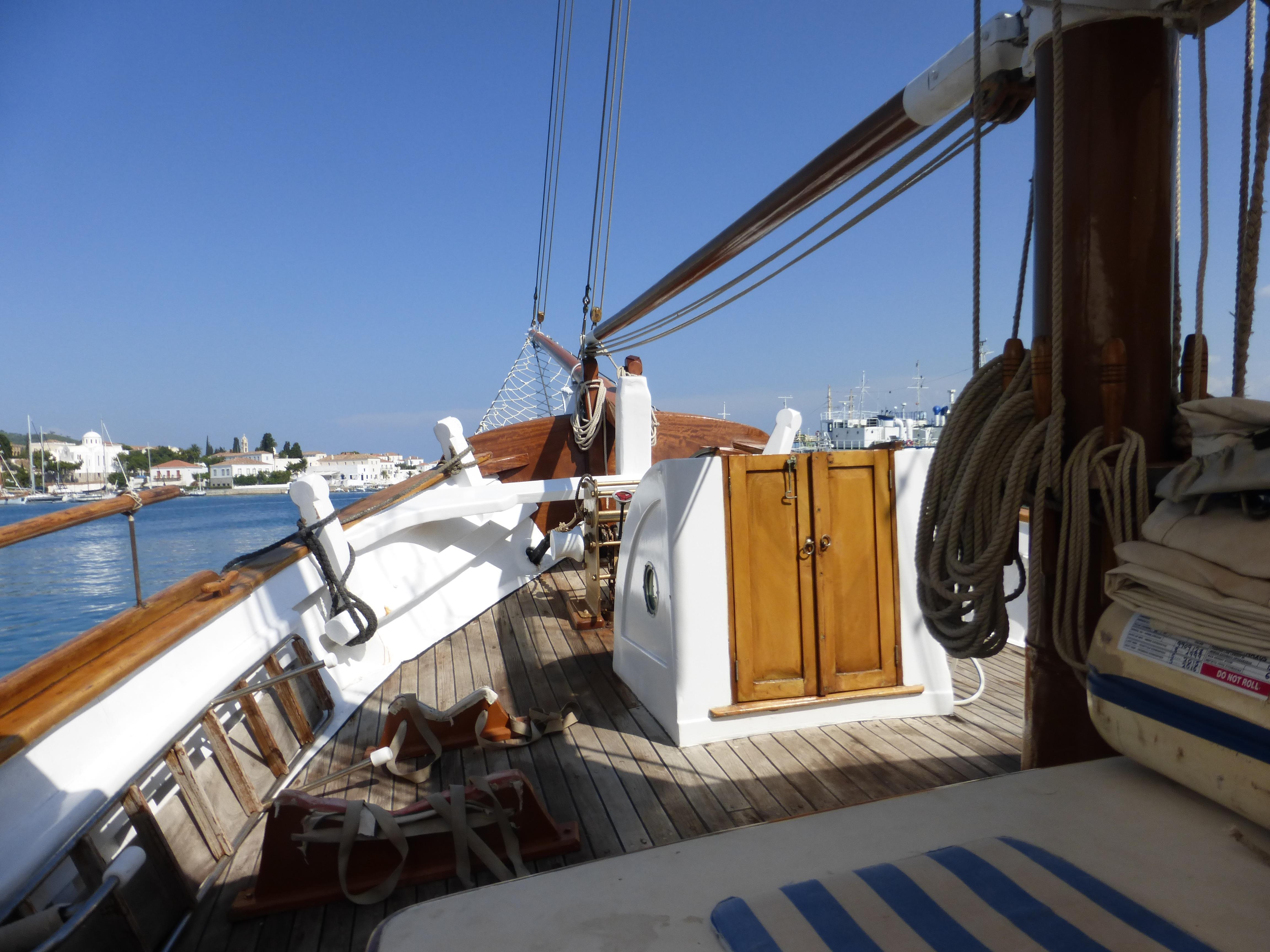 1953 Custom Perama boat deck with wooden features, ropes, and clear blue sky.