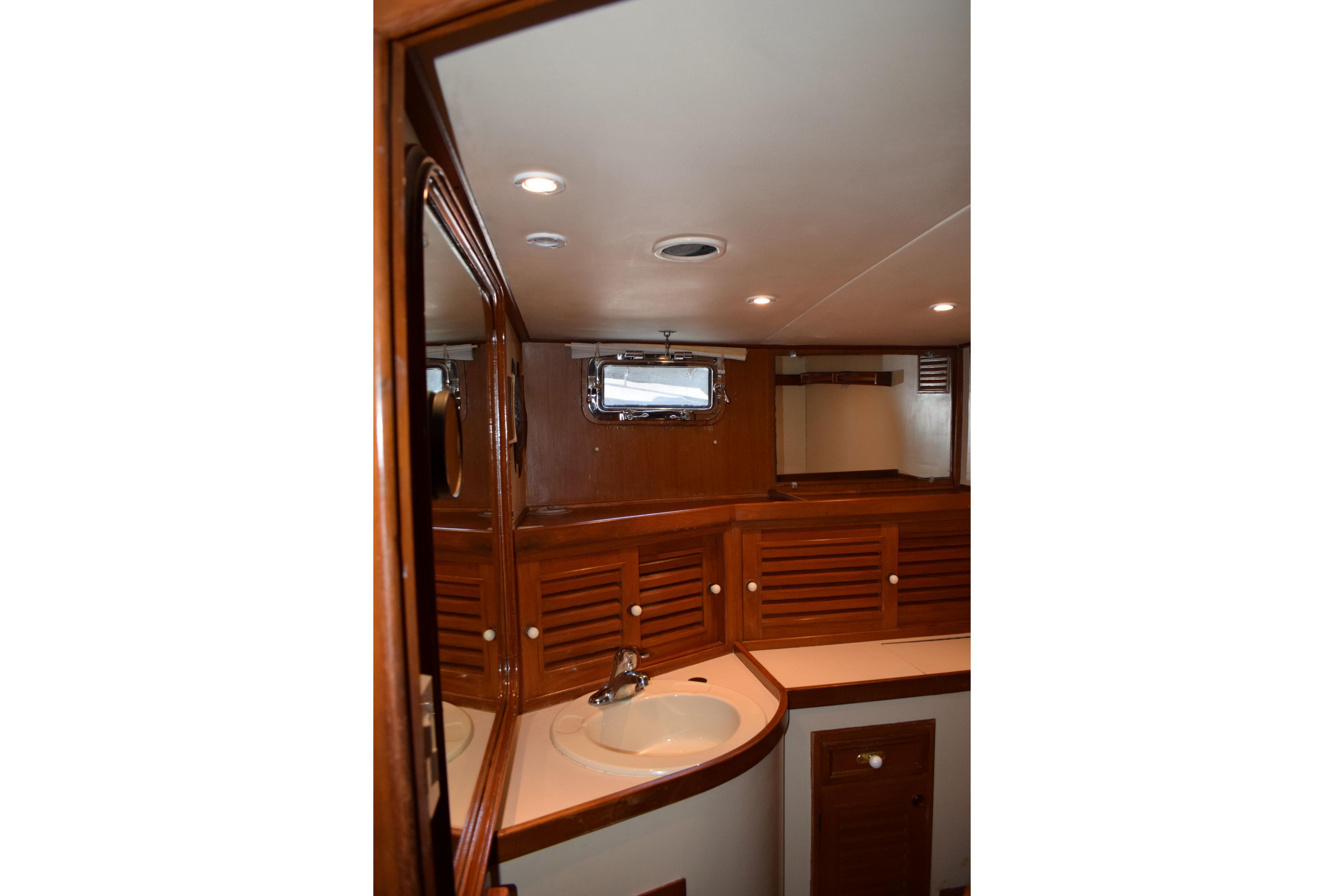 Interior of 1980 Cheoy Lee 52 Motorsailer bathroom with wooden cabinetry and sink.