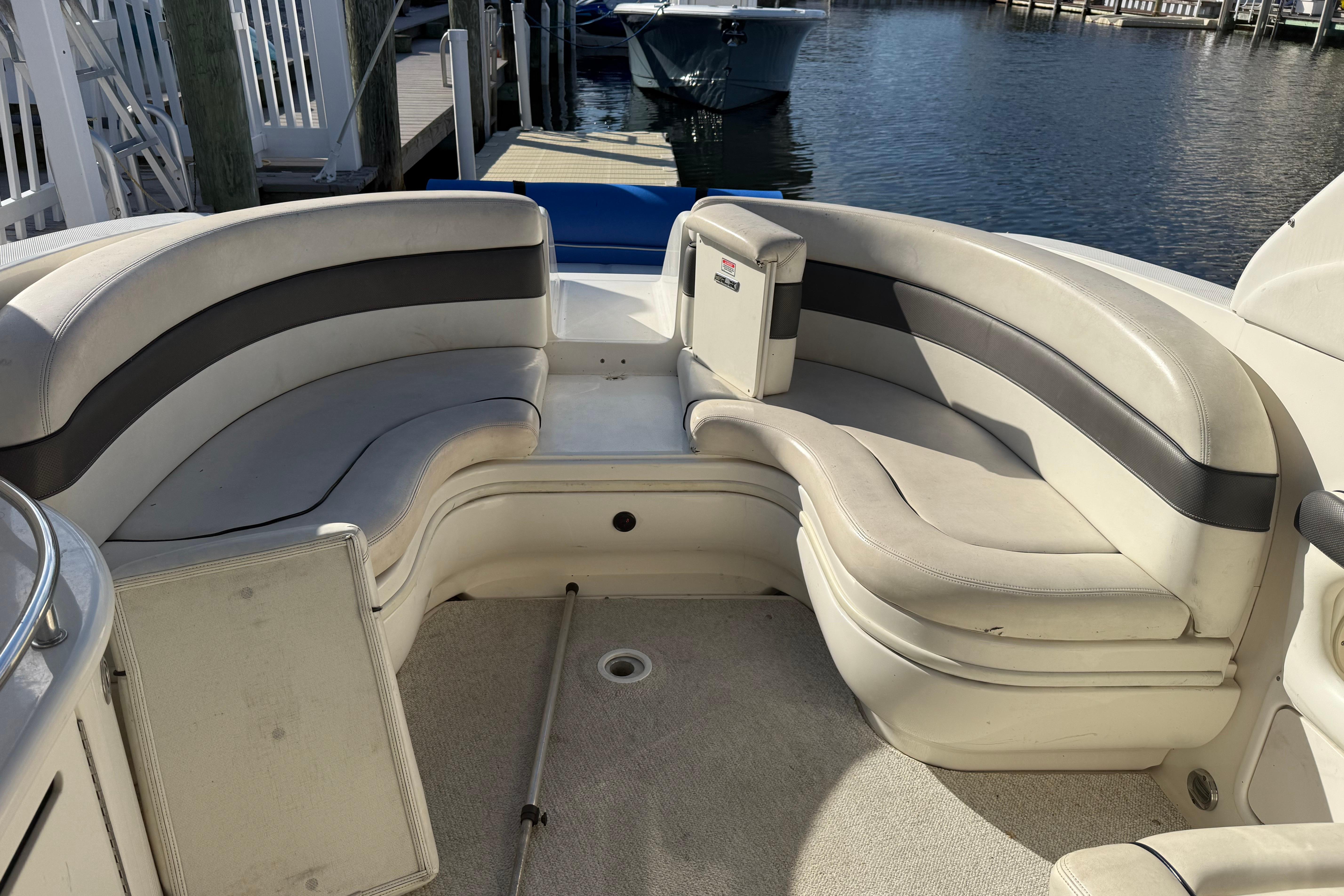 2005 Sea Ray 290 SLX boat interior with curved seating, docked by the water.