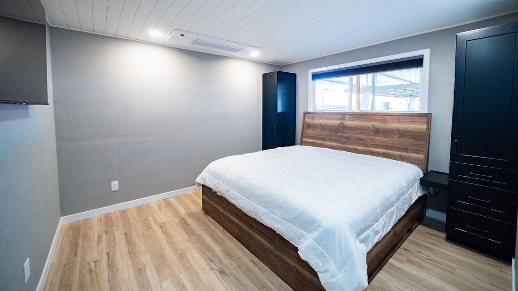 Bedroom in Sumerset Widebody houseboat, modern design, wooden flooring.