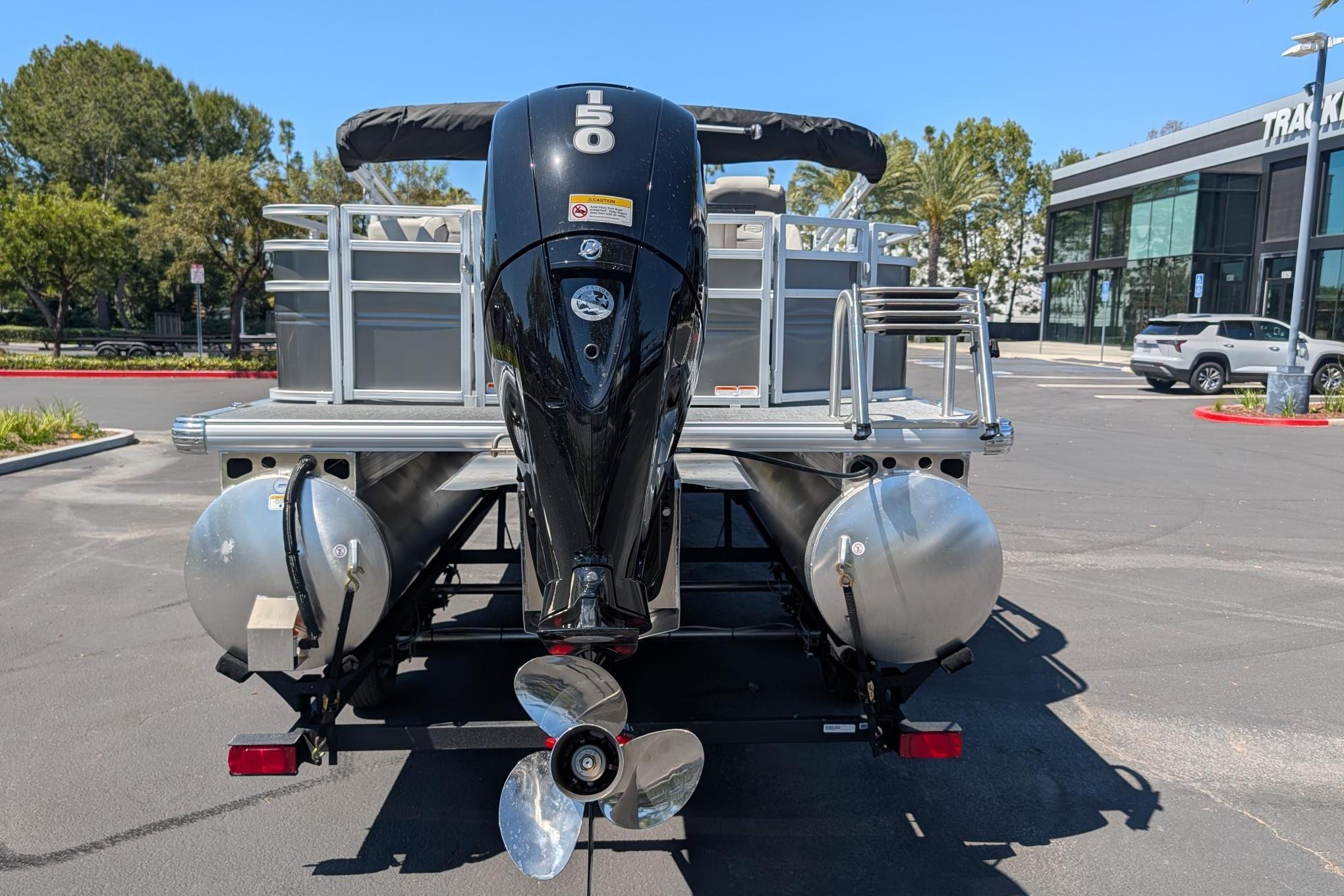 2026 Sun Tracker Fishin' Barge 22 DLX pontoon boat with powerful outboard motor.