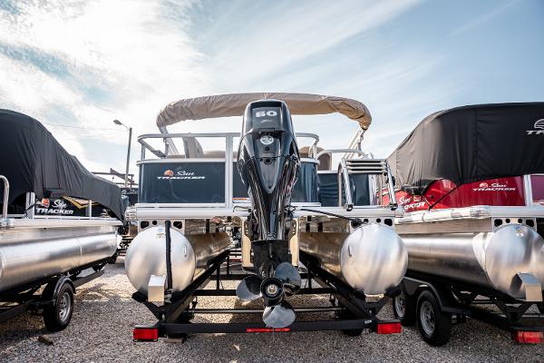 2025 Sun Tracker BASS BUGGY 18 pontoon boat with outboard motor, displayed outdoors.