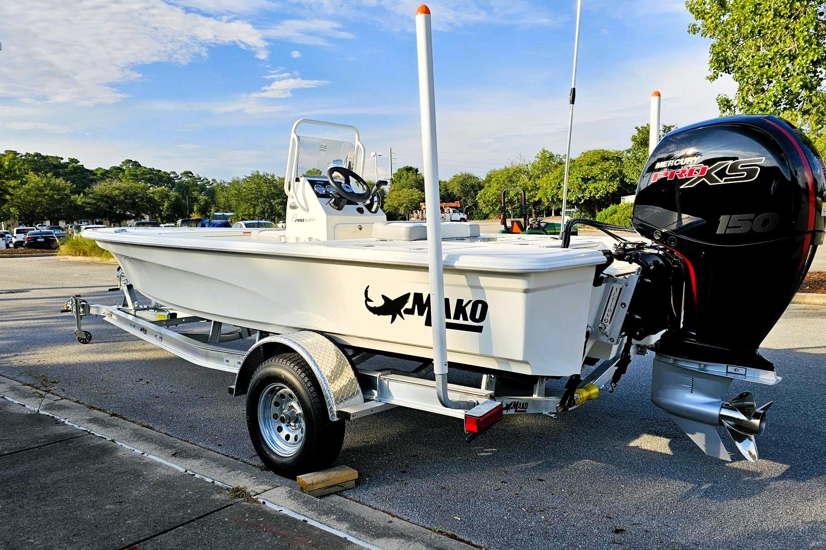 2026 Mako 18 Pro Skiff boat on trailer with Mercury 150 engine in parking lot.
