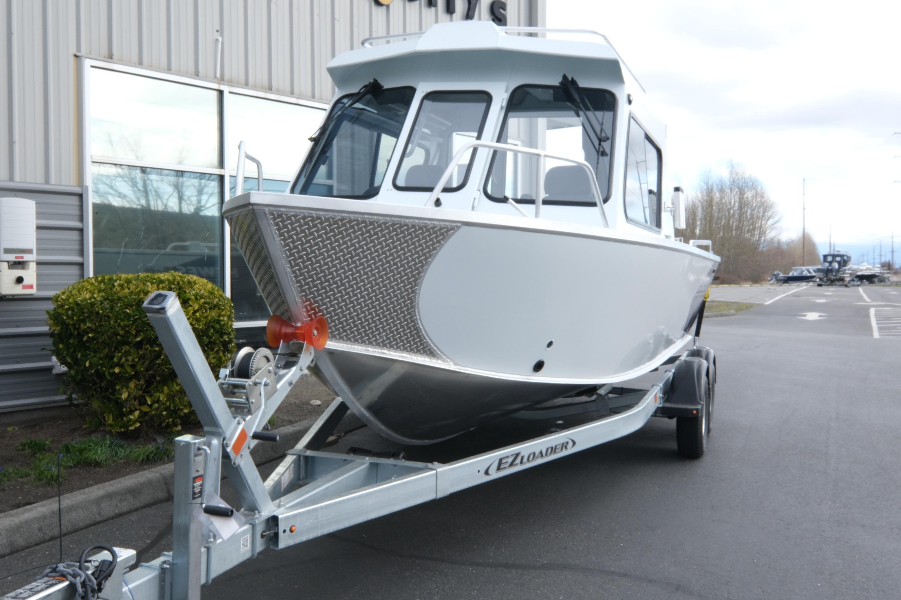 2026 Hewescraft 210 Sea Runner ET Hardtop on trailer, parked outside a building.