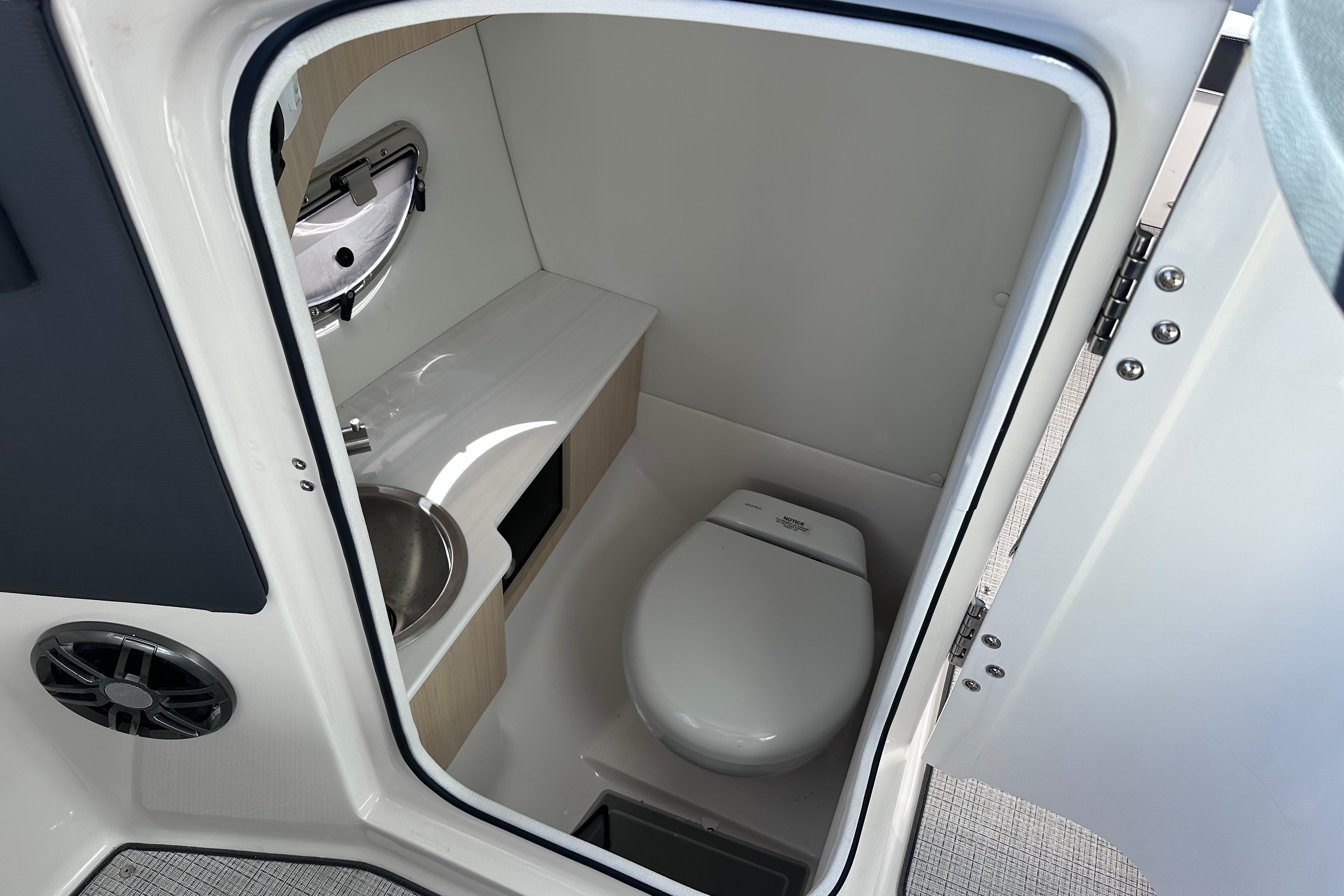Compact bathroom in 2026 Regal LX4 boat with toilet and sink.