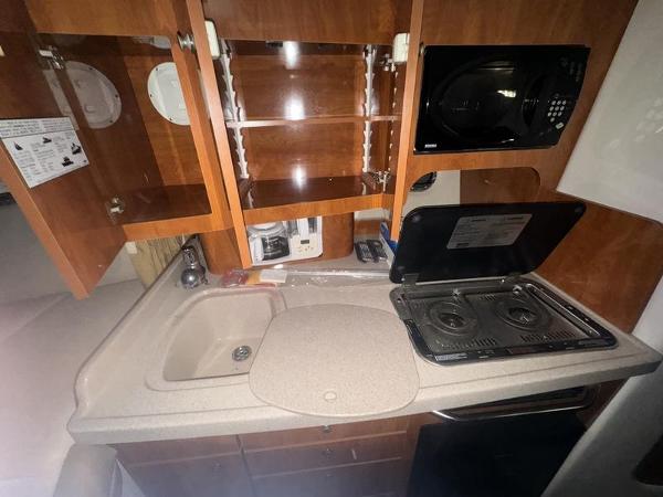 2005 Four Winns 298 Vista boat kitchen with stove, sink, and microwave.