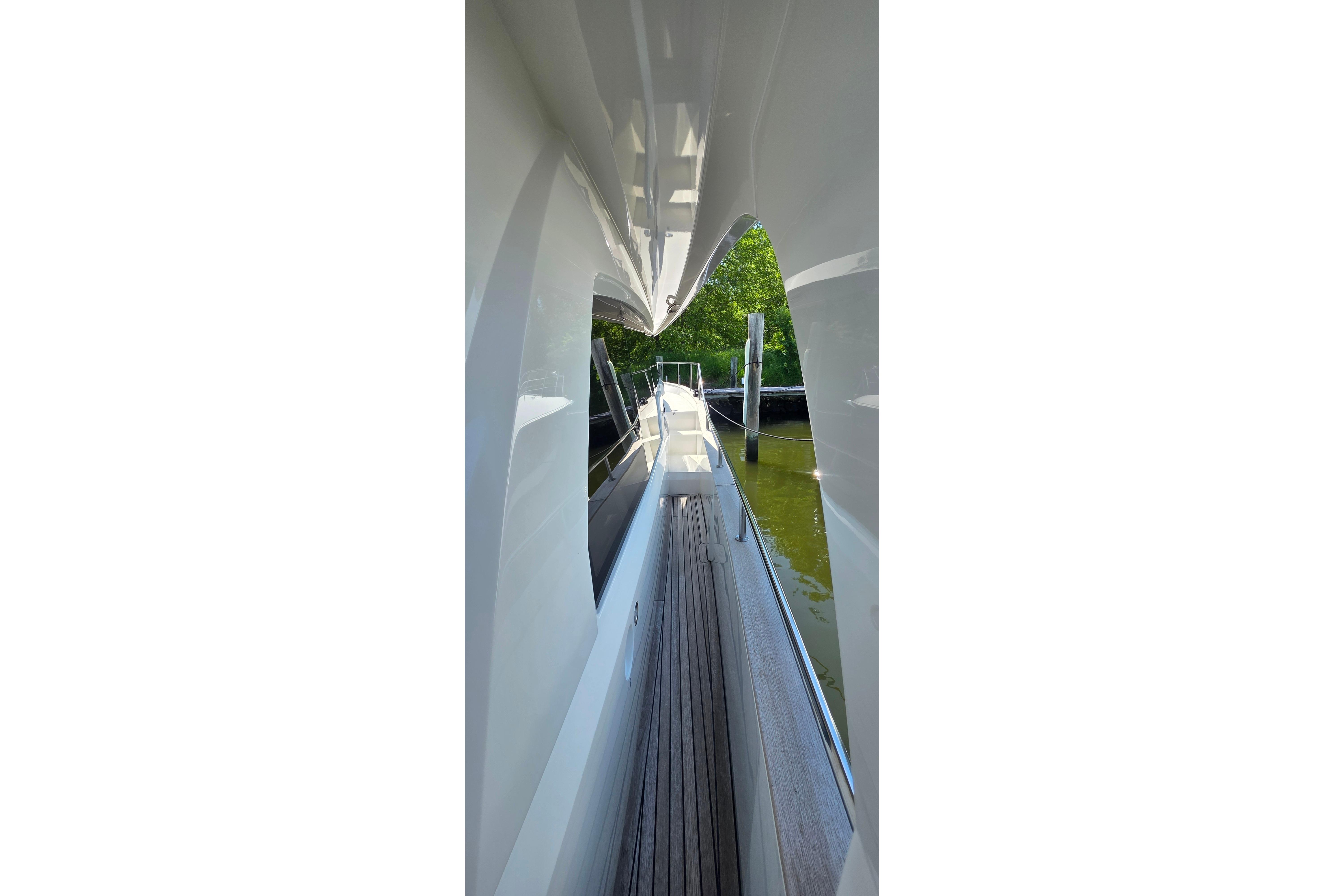 Side view of 2023 Greenline 40 yacht, showcasing sleek design and wooden deck.