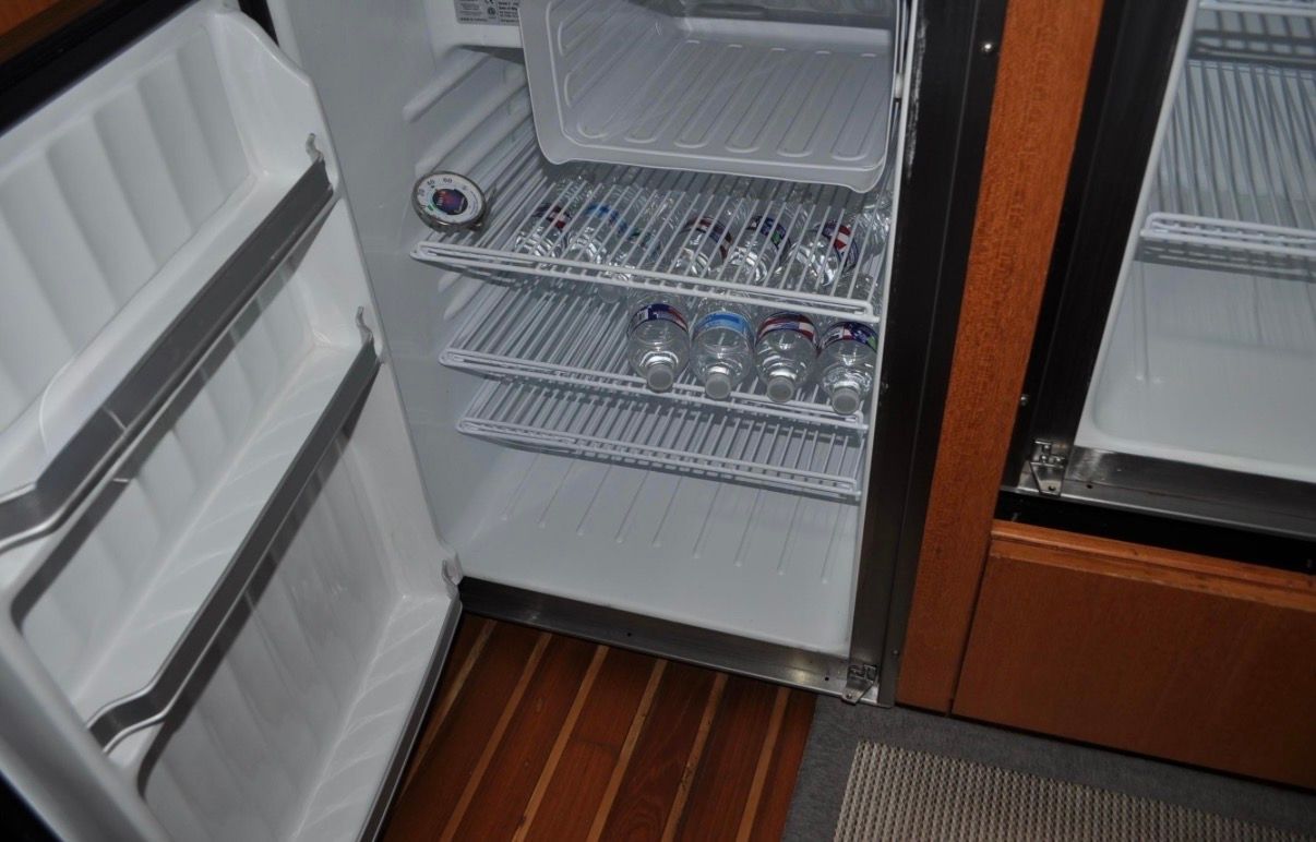 Open refrigerator with beverage cans inside.