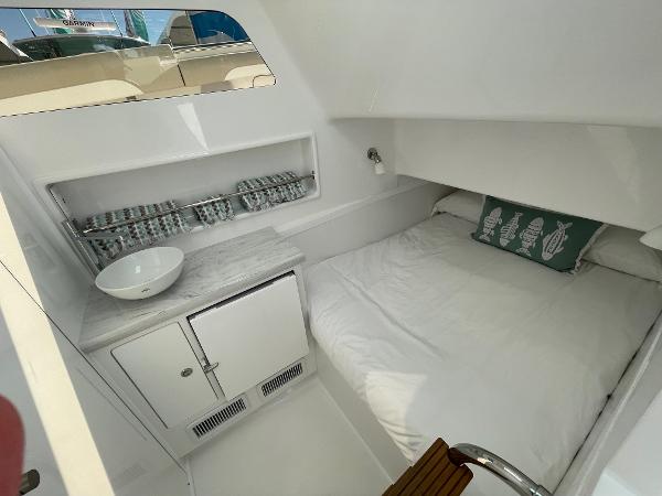 2025 Mag Bay 43 Center Console cabin with bed, sink, and storage.