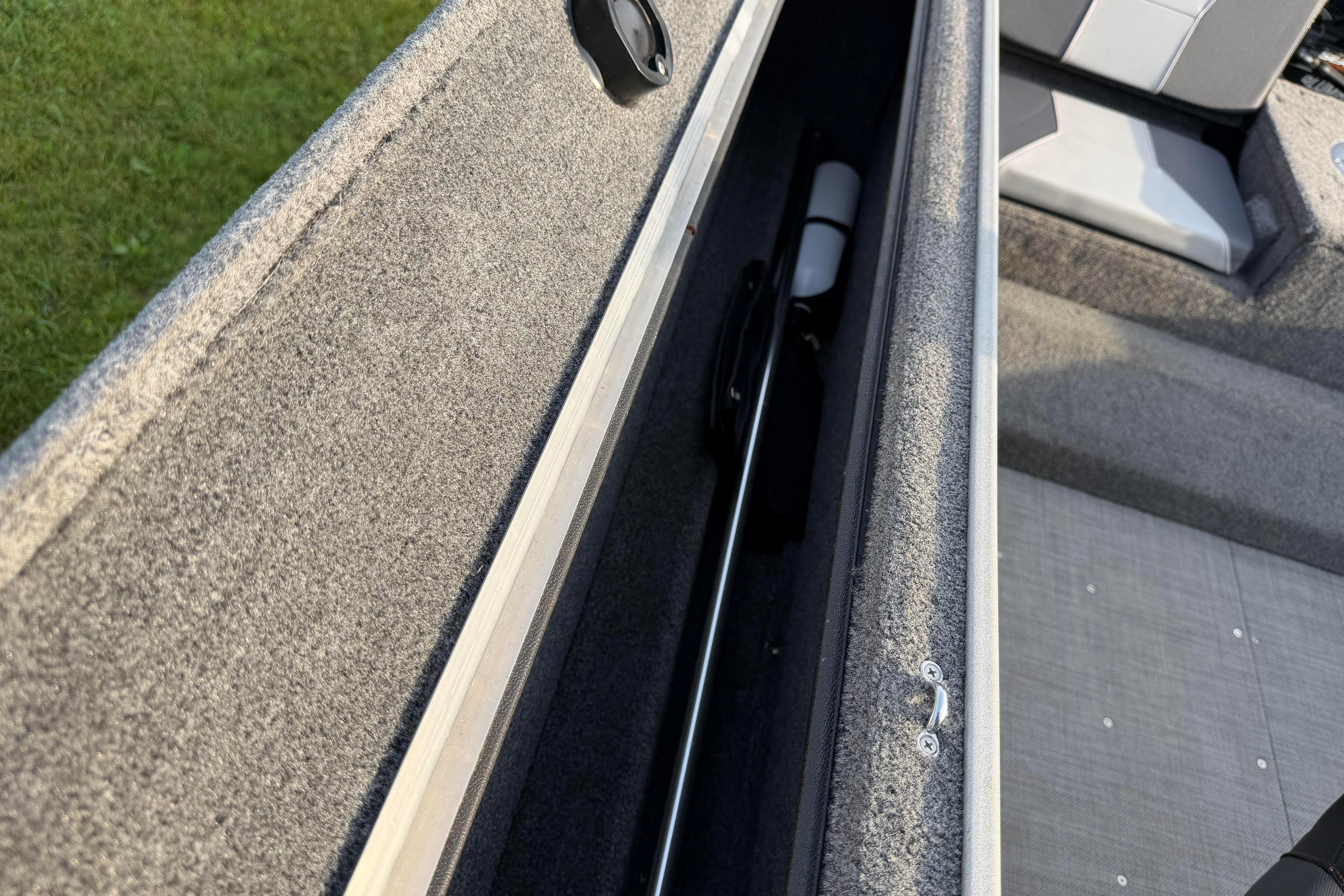 2019 Alumacraft Trophy 205 boat interior storage compartment with carpeted finish.