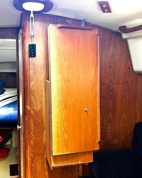 Interior of 1986 Pearson 303 sailboat with wooden cabinetry and cozy seating.