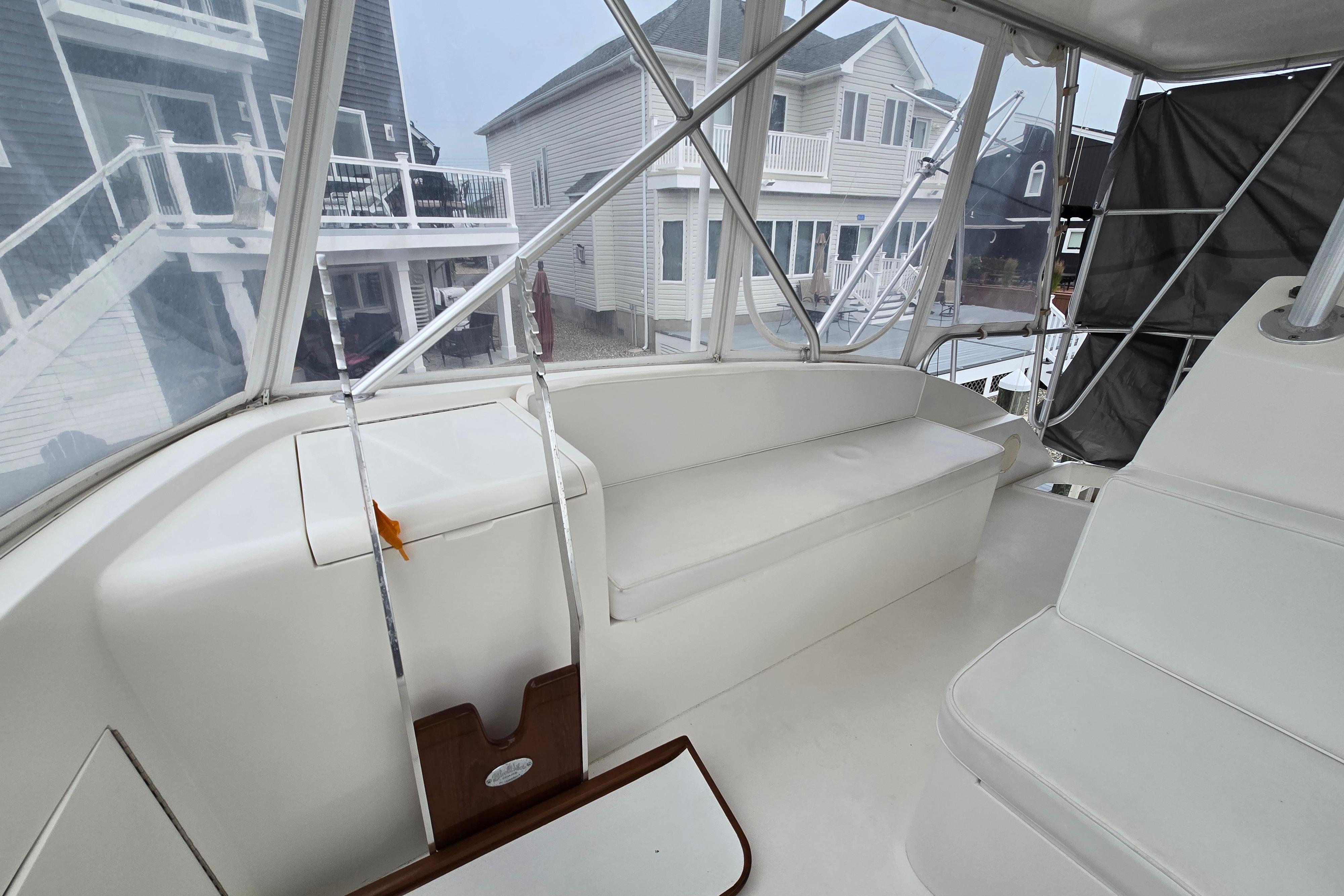 Interior view of a 2001 Cavileer 53 Convertible yacht with white seating and clear windows.